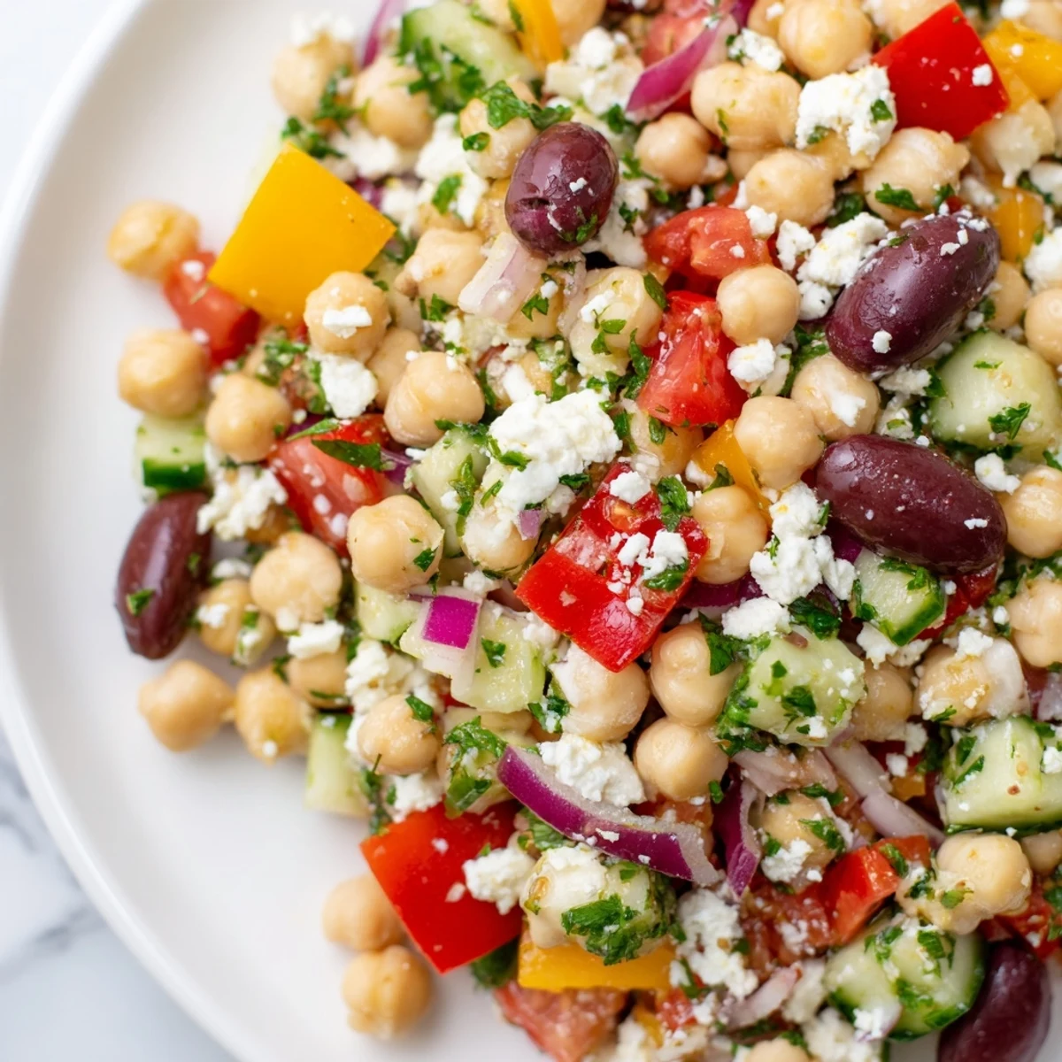 Overhead view of a vibrant Mediterranean Chickpea Salad, highlighting the red bell peppers and chickpeas glistening with zesty lemon dressing, ready to serve.