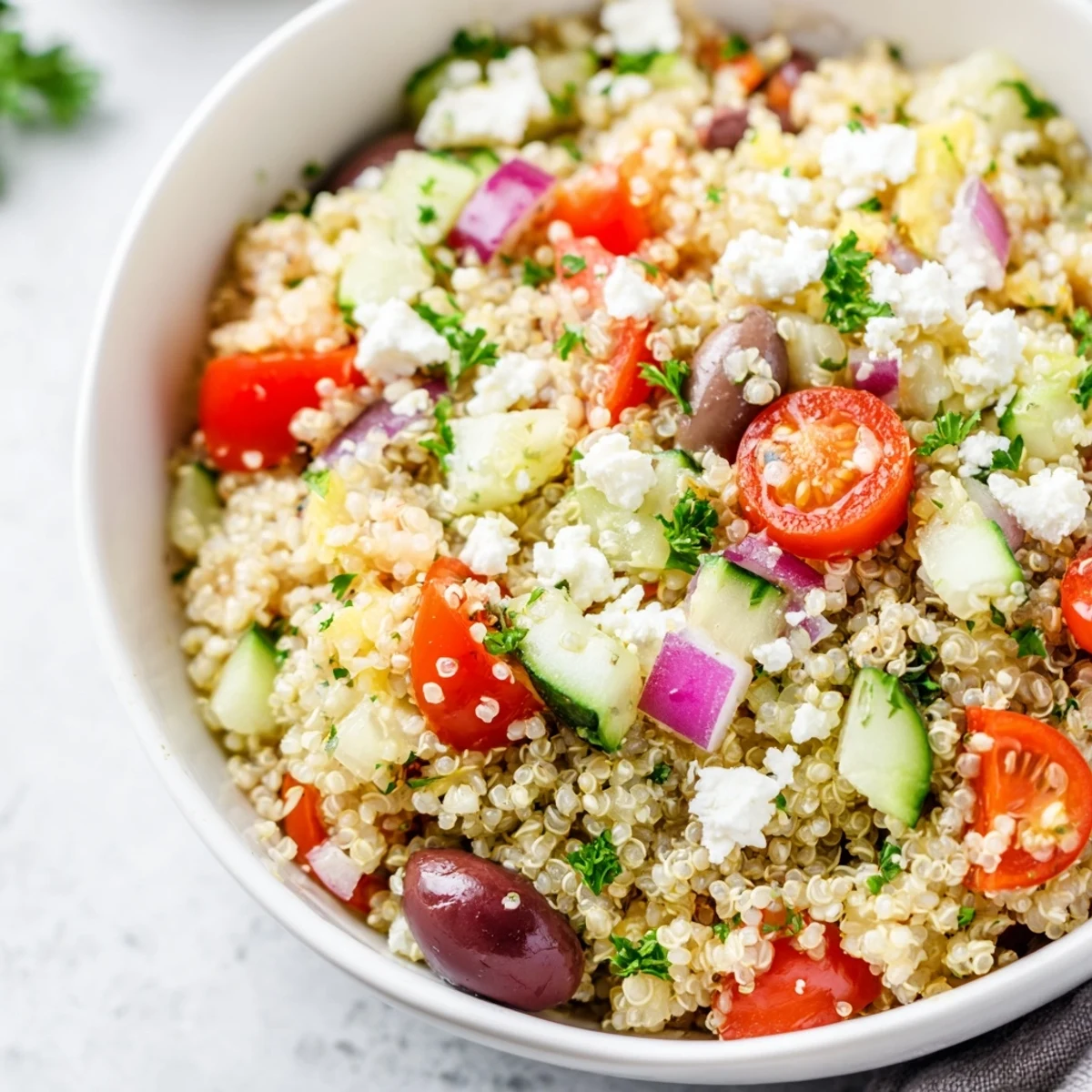 Bright Mediterranean Quinoa Salad with Tomatoes is tossed in a light lemon-oregano dressing and served chilled in a rustic bowl.
