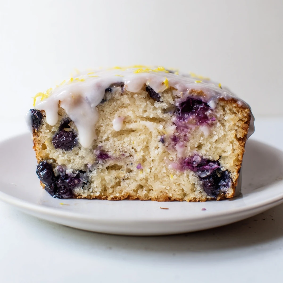 Freshly baked Lemon and Blueberry Yogurt Loaf with a moist crumb, bright lemon glaze, and juicy berries, perfect for breakfast or snack.
