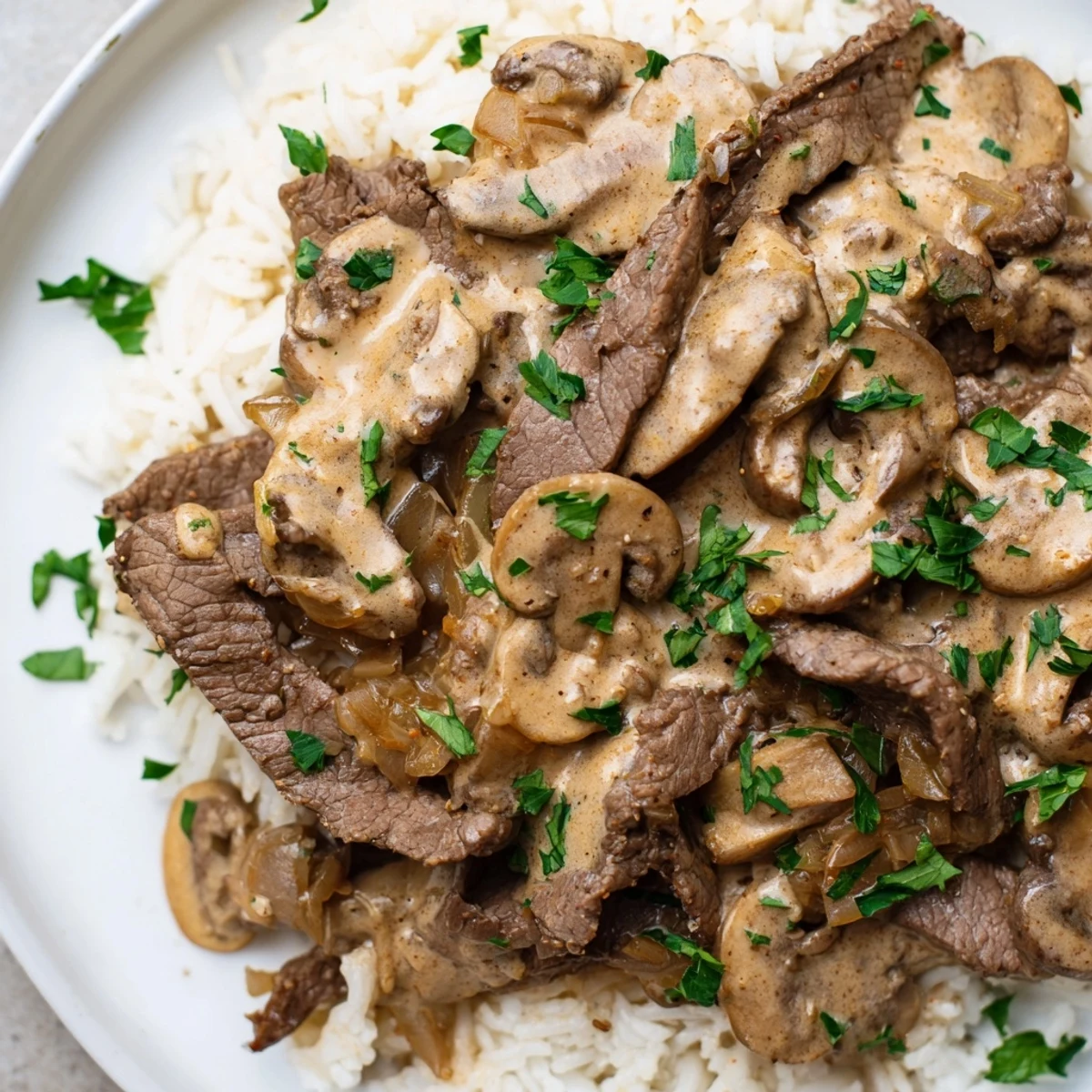Creamy Beef Stroganoff with Basmati Rice served in a white bowl, garnished with fresh parsley.