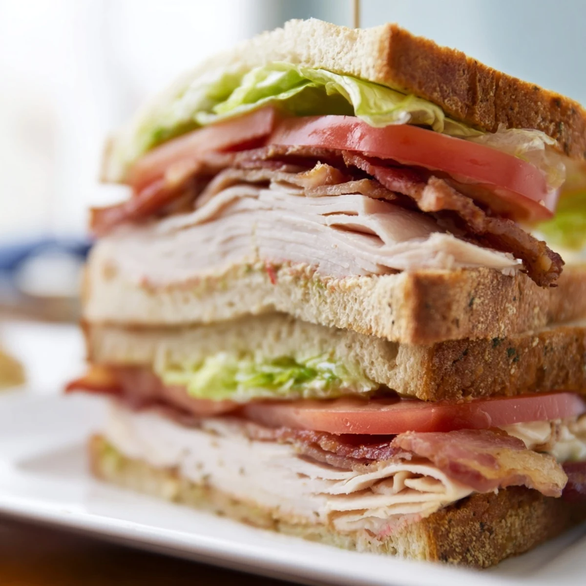 Thick-cut beef bacon and roasted turkey layered with creamy mayonnaise on this hearty Turkey Club Sandwich with Beef Bacon.