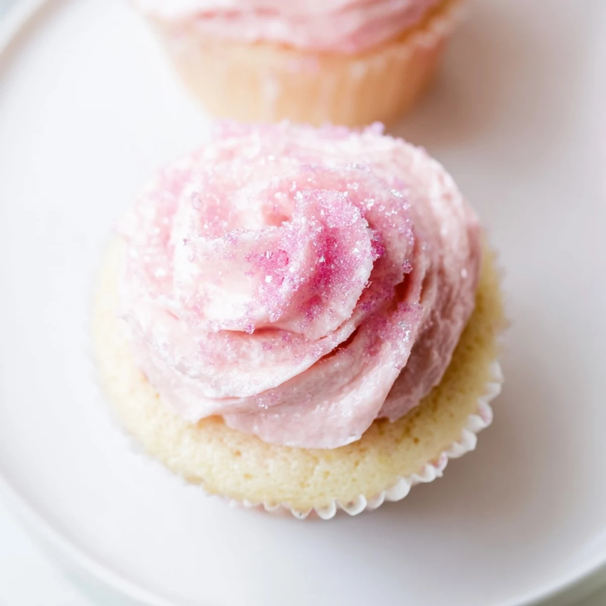 A batch of Pink Champagne Cupcakes with fluffy texture and pastel pink frosting, arranged on a dessert platter.