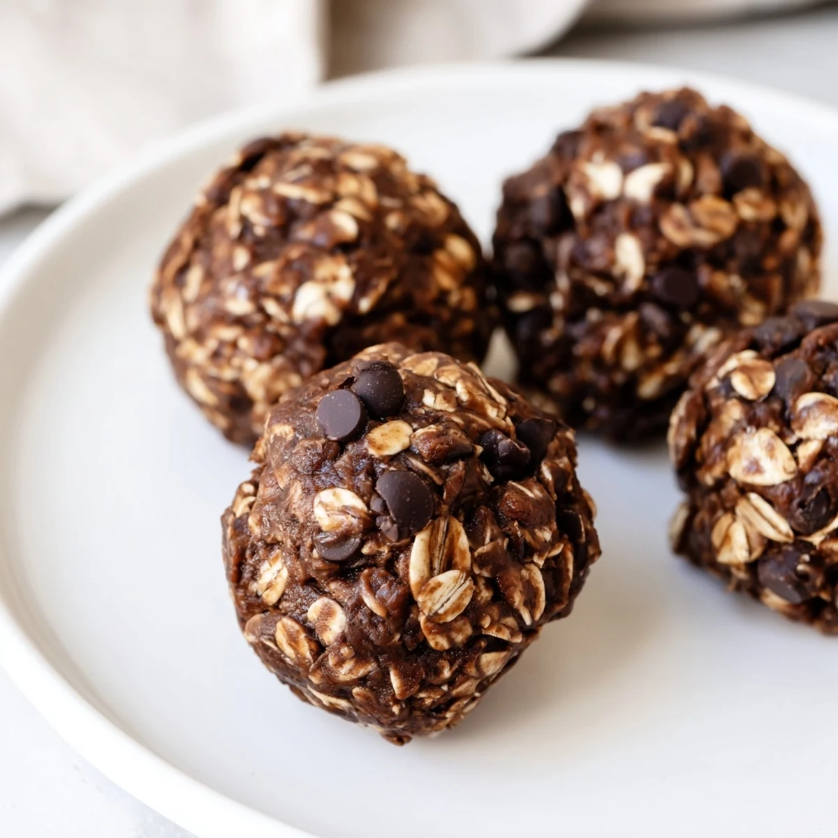 Chilled chocolate peanut butter energy balls are rolled oats, cocoa, and mini chocolate chips in a no-bake snack.  