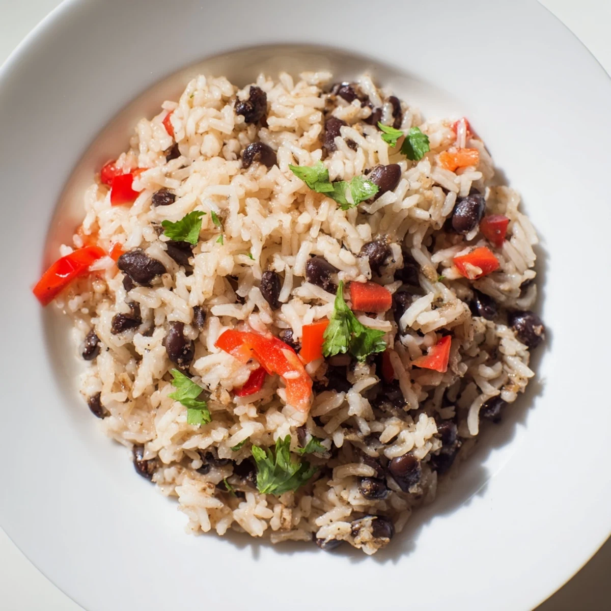 Warm bowl of vegetarian rice and beans, topped with fresh cilantro and a bright lime wedge.