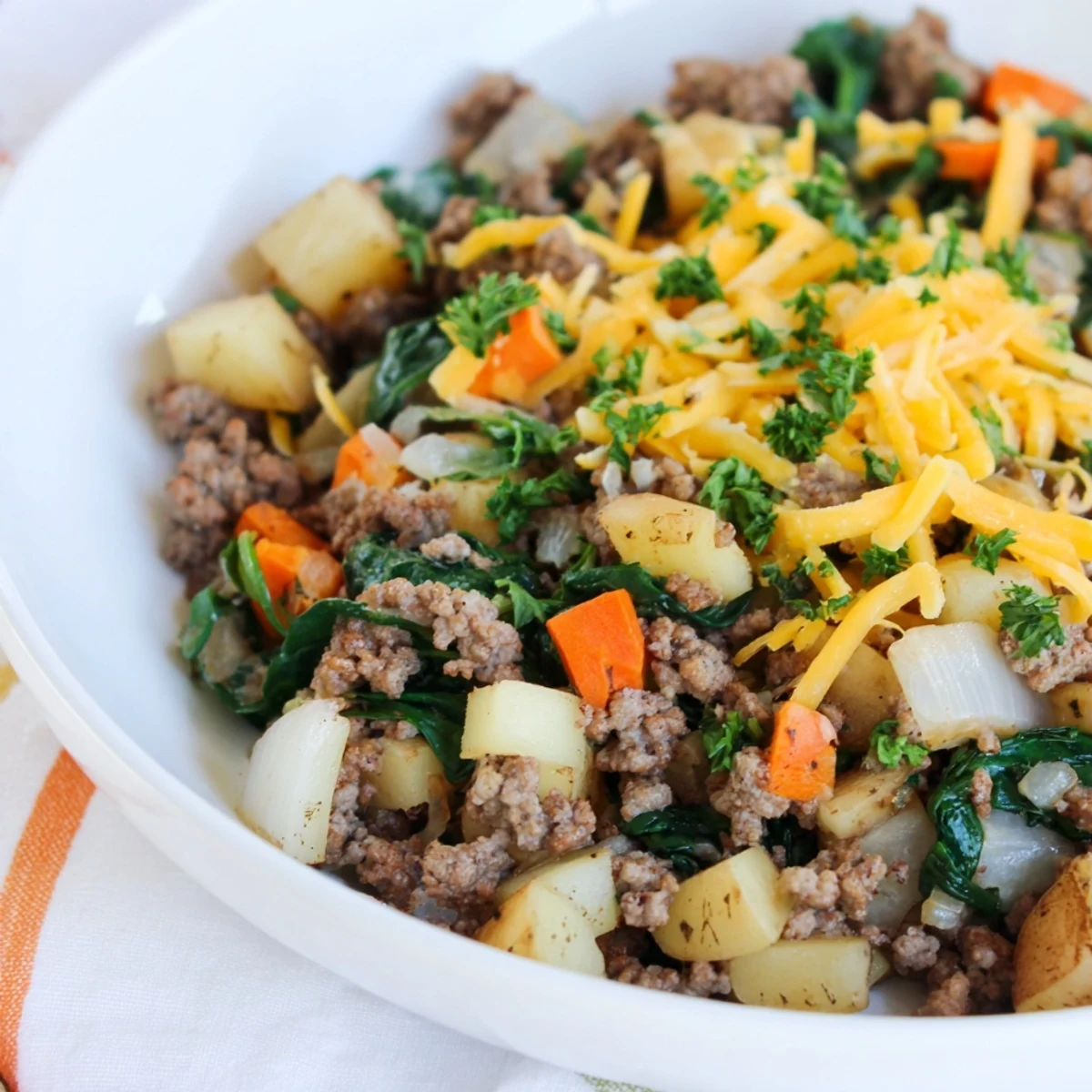 Sizzling lean ground beef and diced potatoes with smoked paprika in a pan for dinner.
