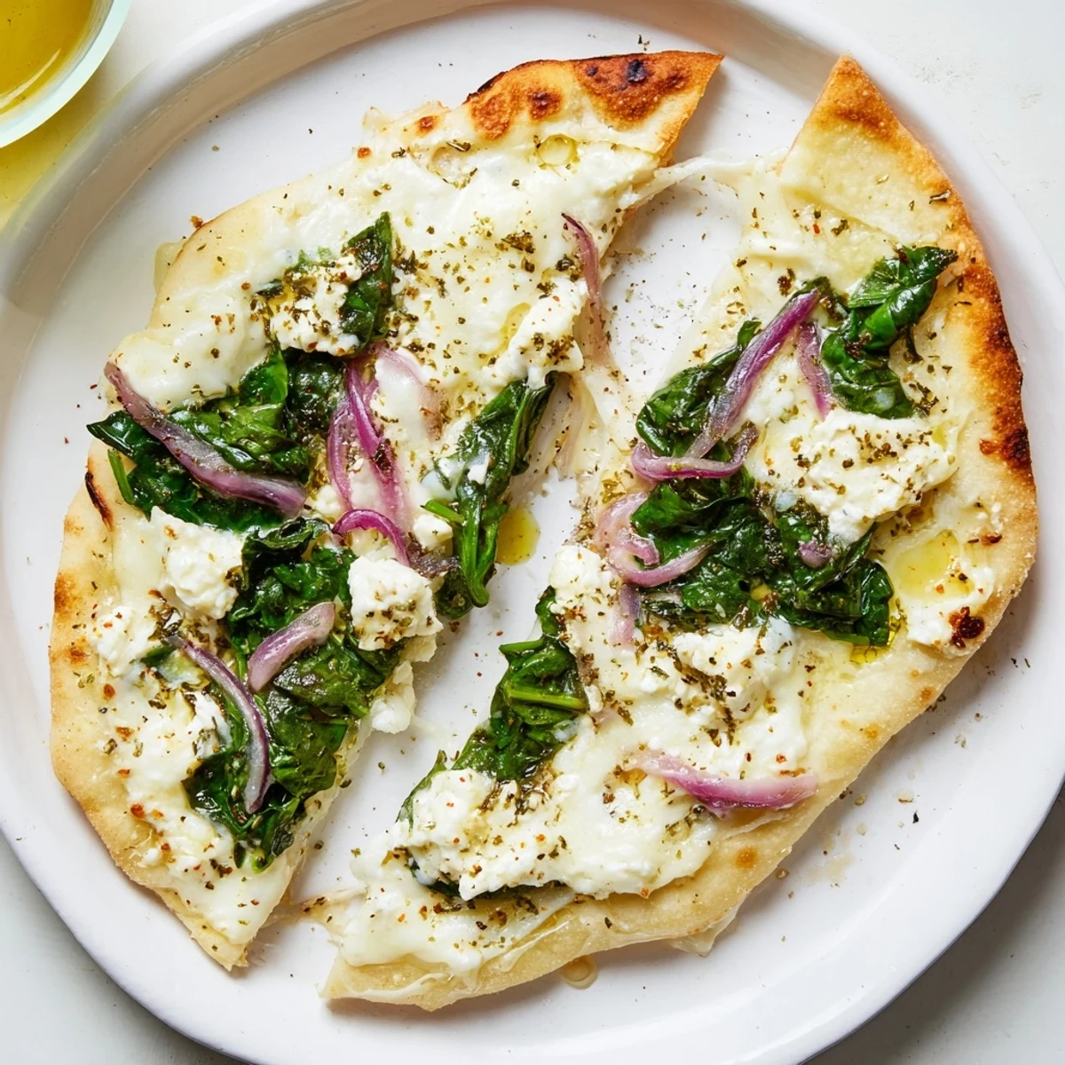 Fresh baby spinach and crumbled feta cheese top this easy Mediterranean flatbread pizza.  