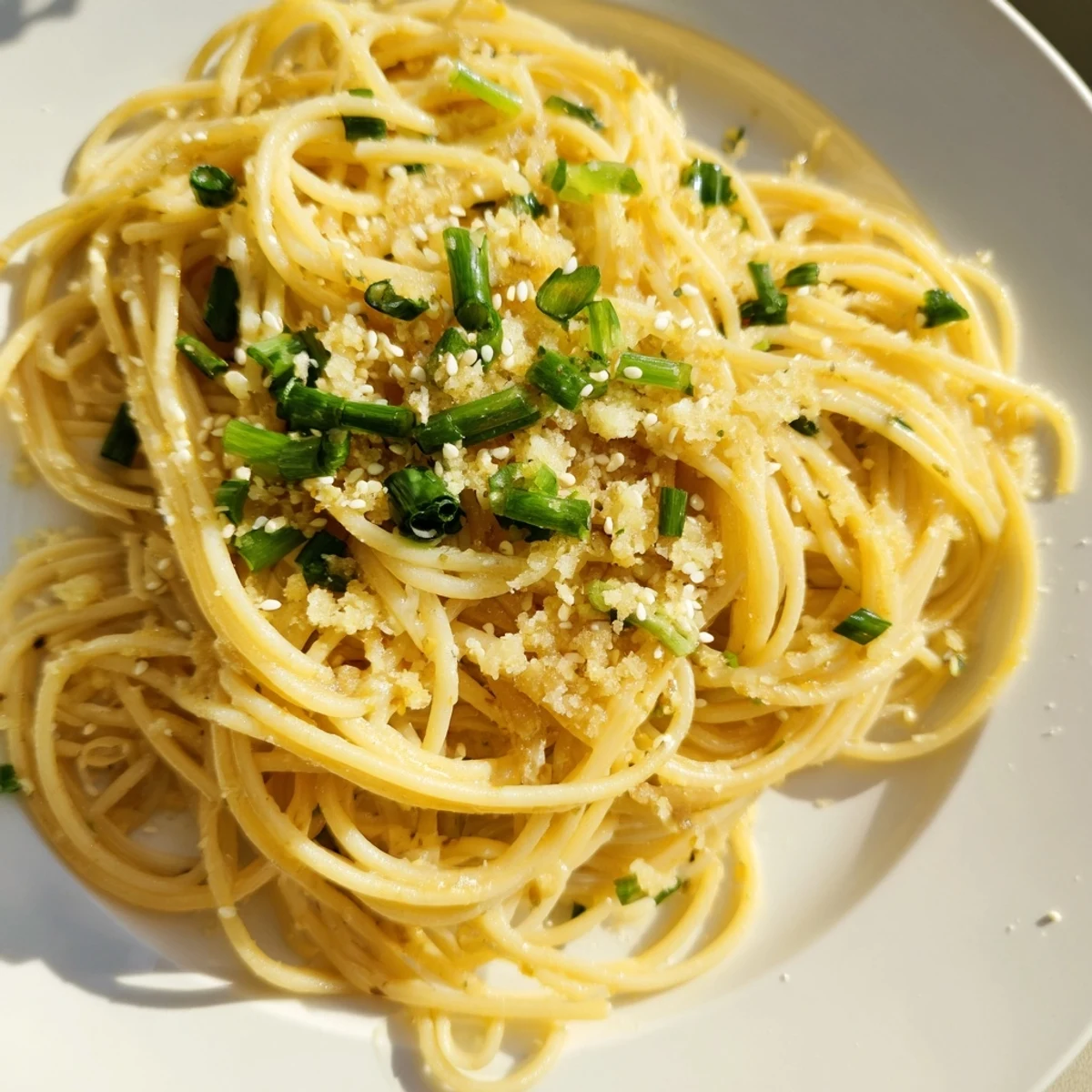 A close view of Garlic Noodles in a skillet with scallions and sesame seeds.