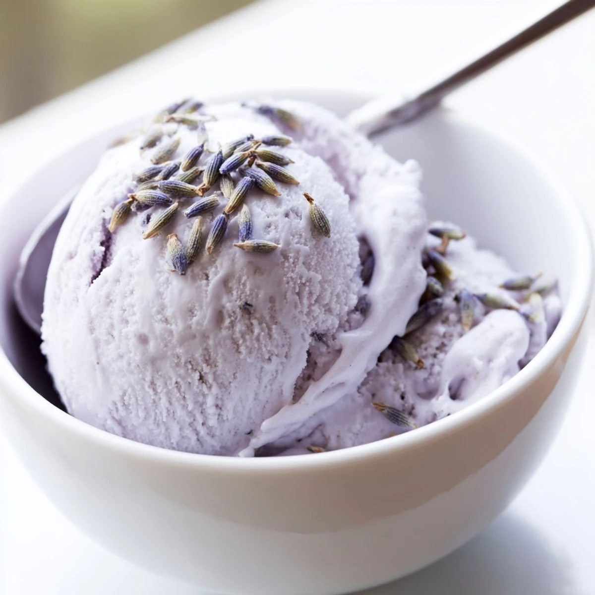 A slice of shortbread cookie beside a bowl of homemade lavender ice cream for an elegant dessert pairing.