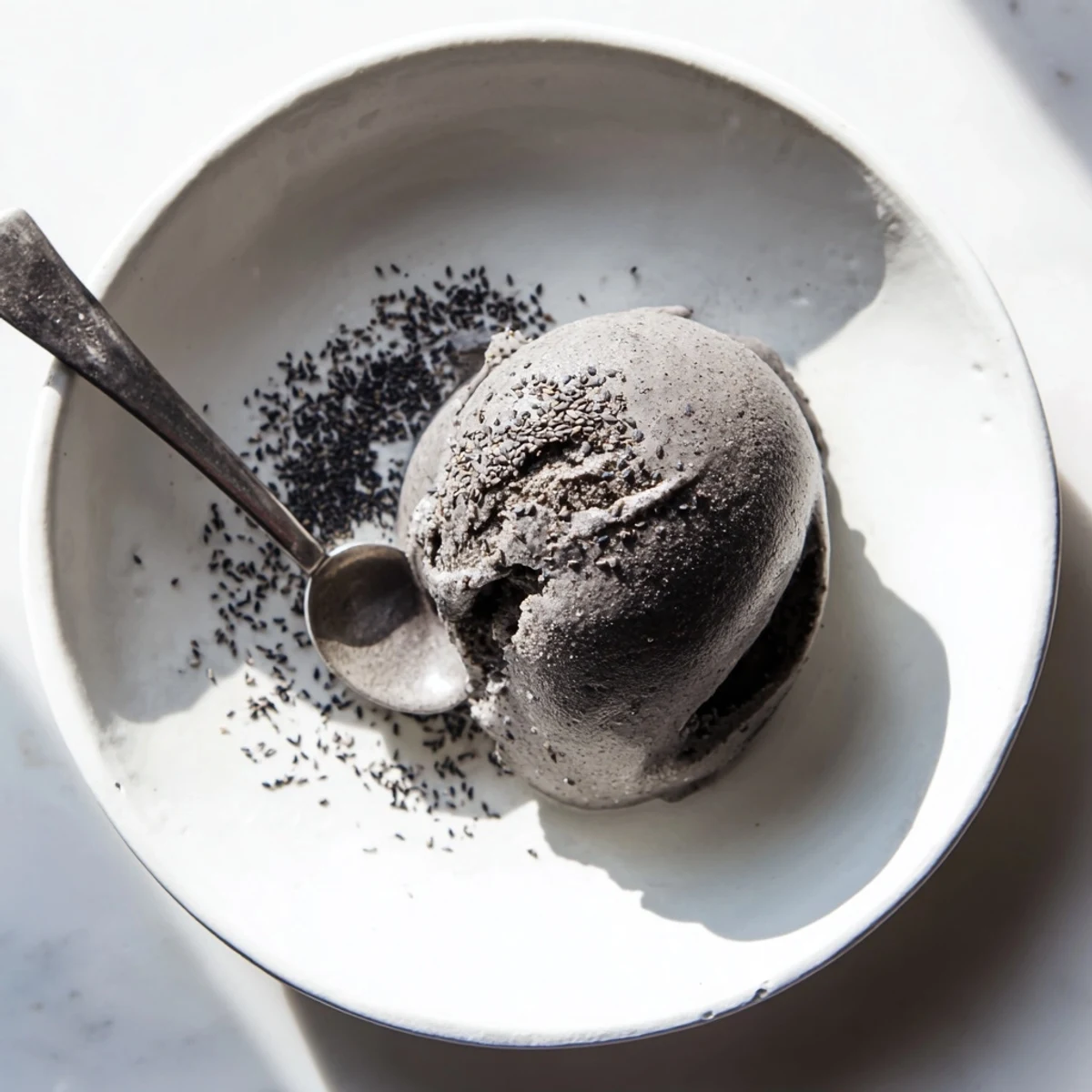 Close-up scoop of rich black sesame ice cream with a nutty aroma and smooth texture.