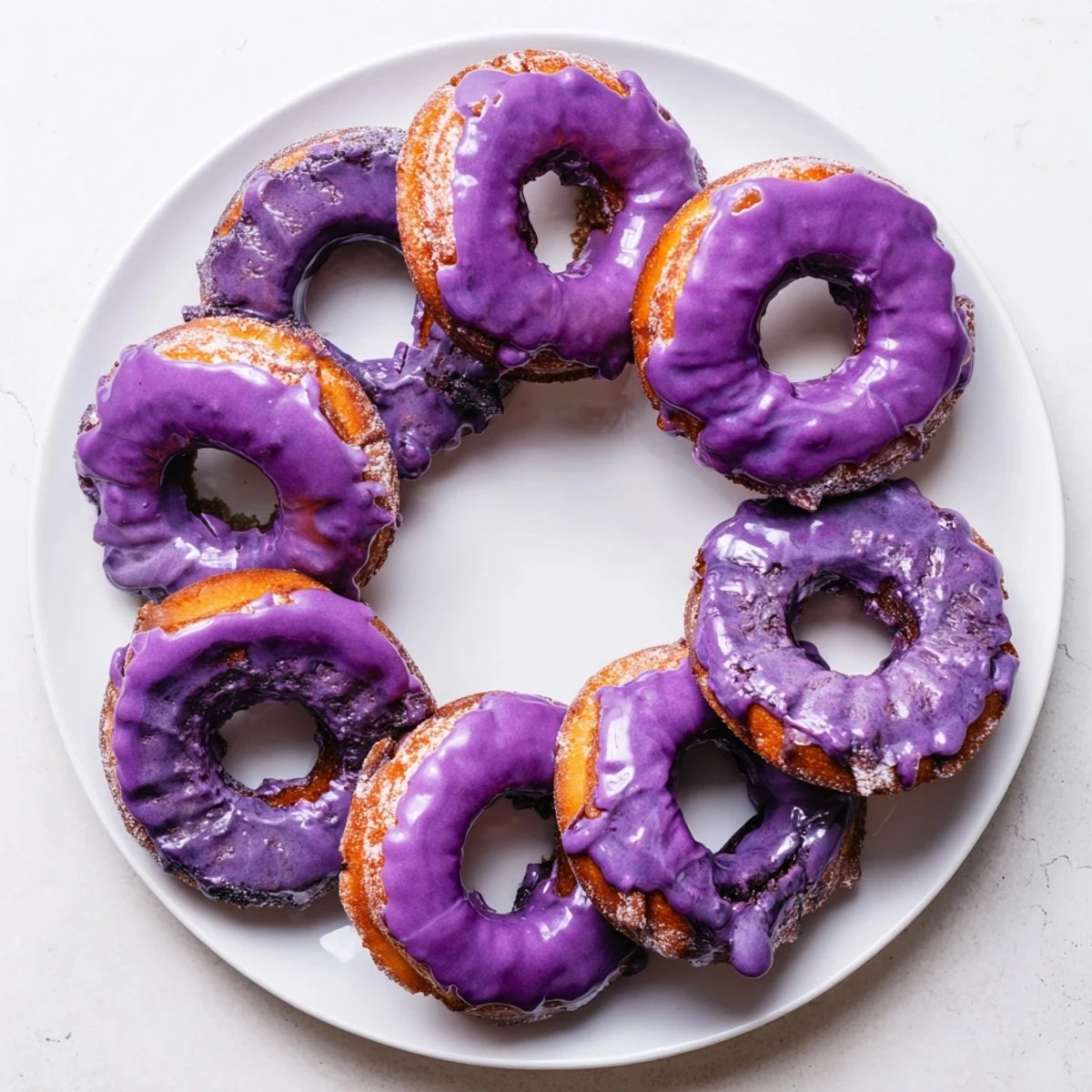 Freshly fried ube mochi donuts display a crispy exterior and soft, chewy interior texture.