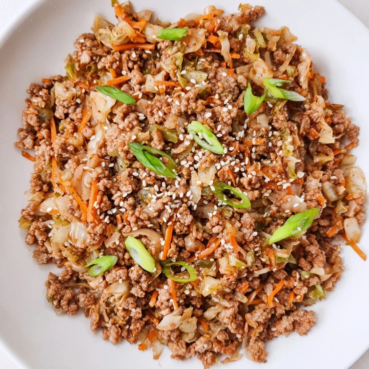 Hearty serving of Egg Roll In A Bowl topped with fresh green onions and sesame.