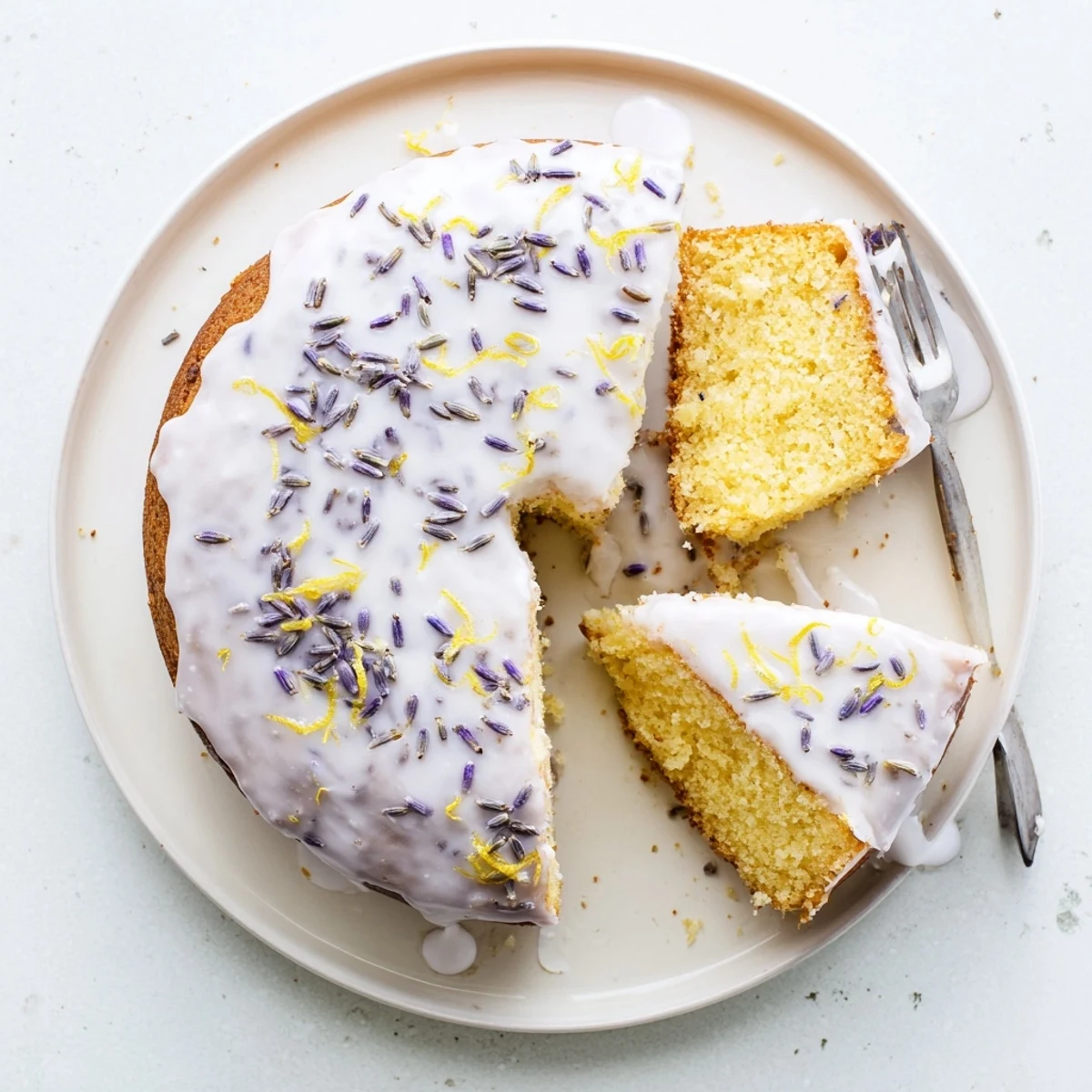 Freshly baked Lemon Lavender Cake with a golden crust, brushed with syrup and garnished with edible lavender buds.