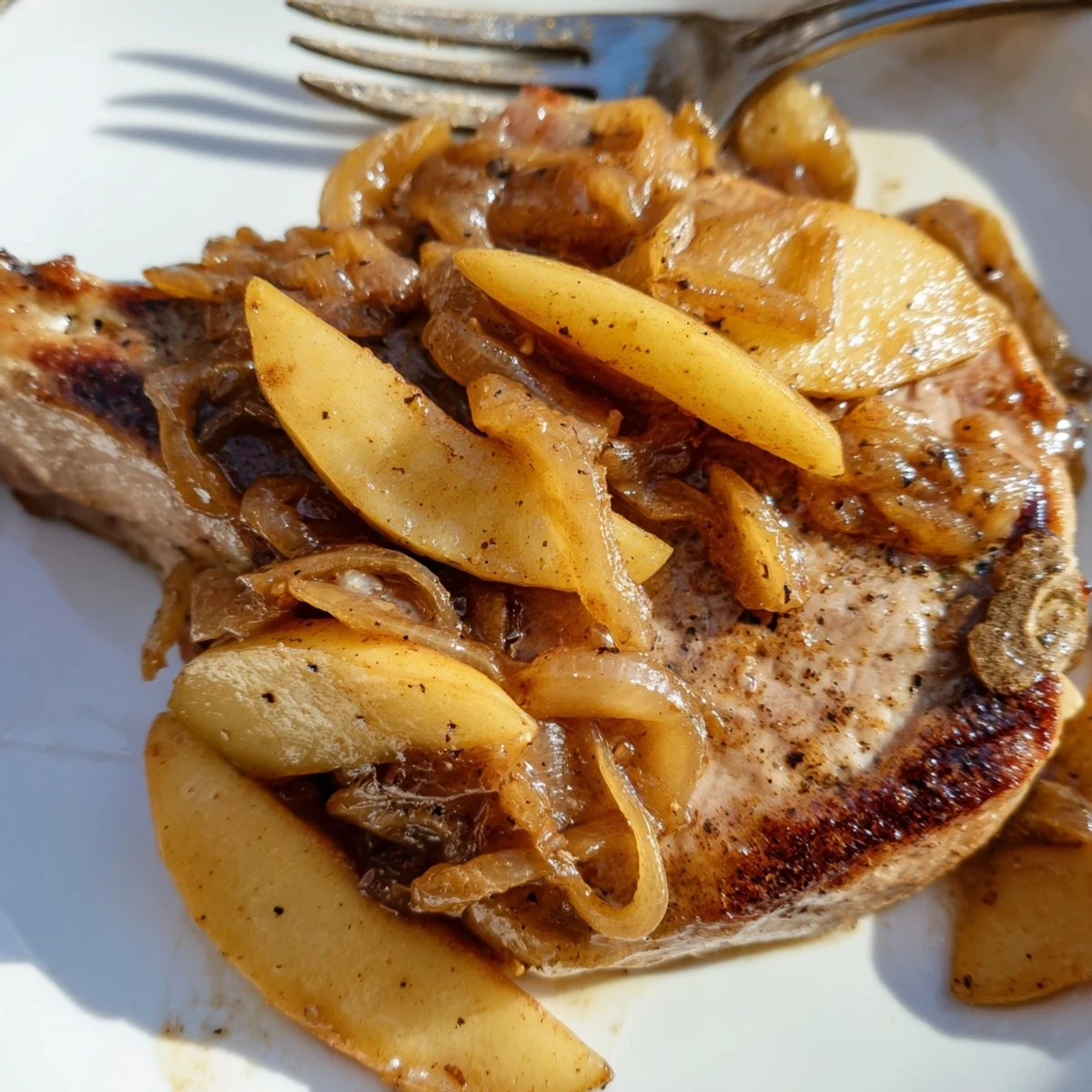 Golden brown pan-seared pork chops glazed in rich apple butter sauce with caramelized apple slices