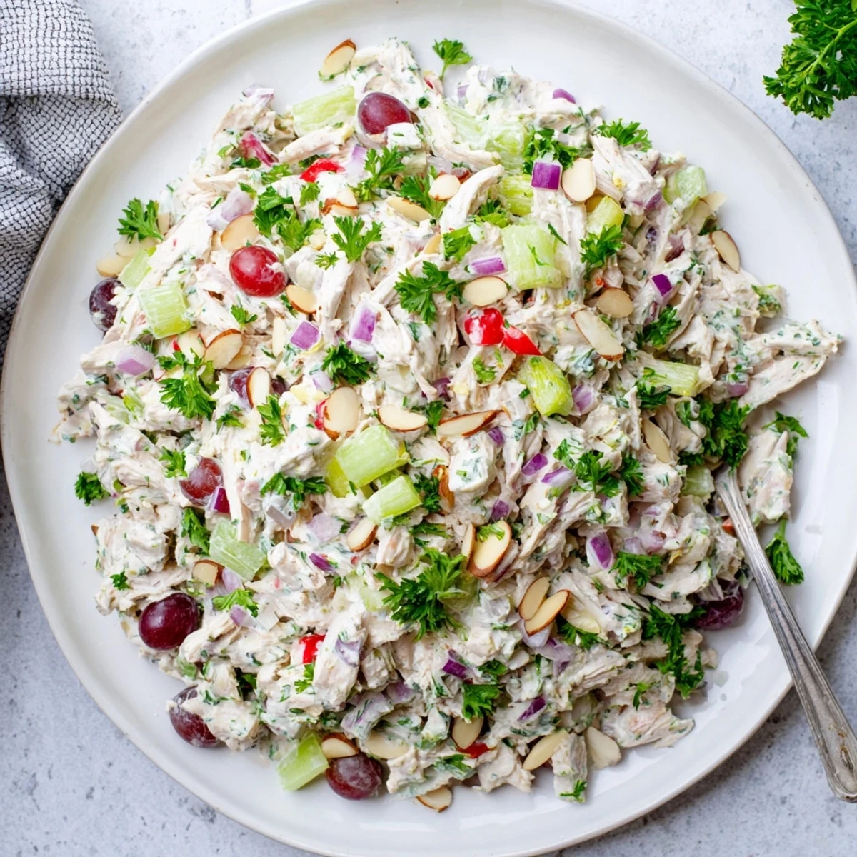 Creamy Greek yogurt rotisserie chicken salad with crisp vegetables and fresh herbs in a white bowl.