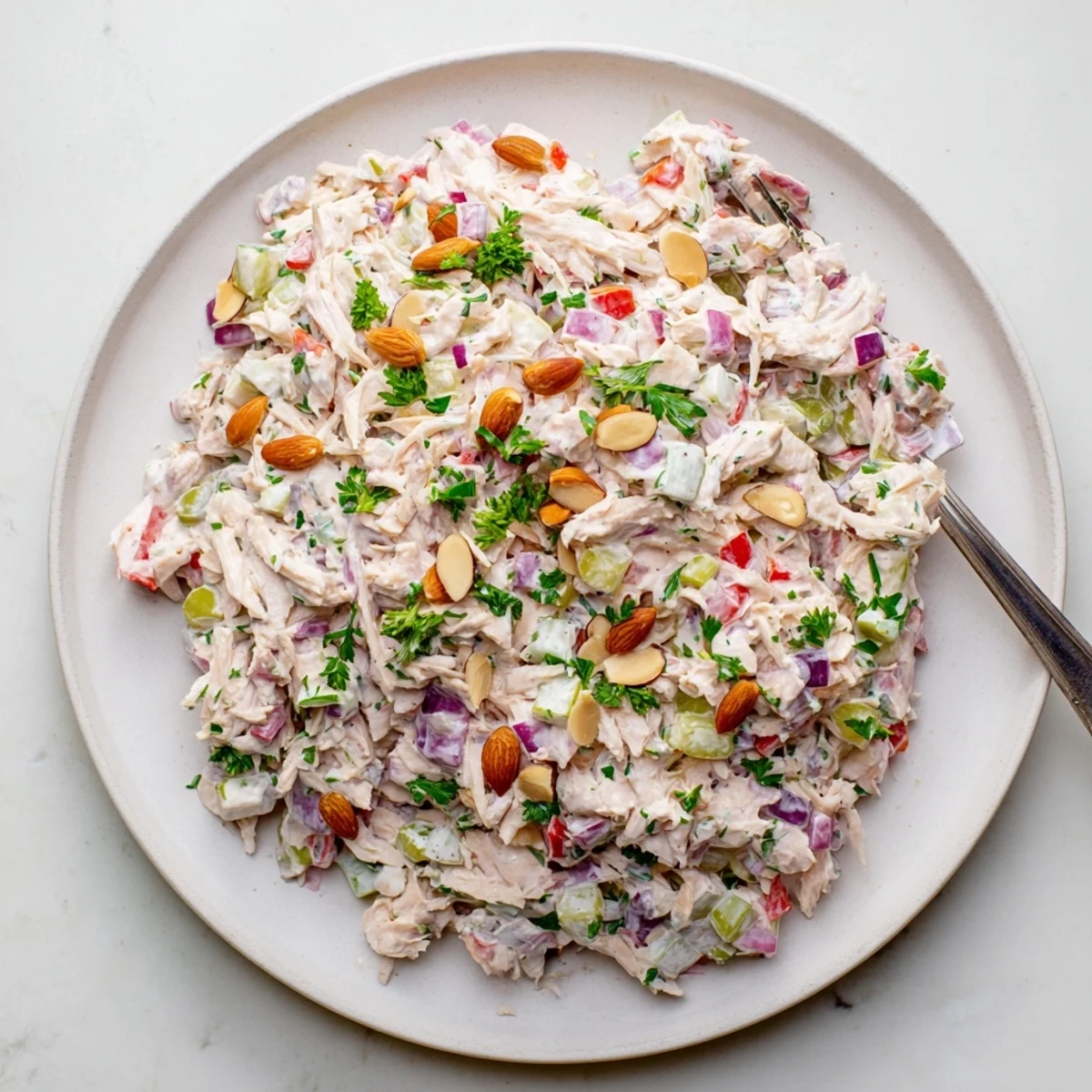 Healthy Greek yogurt rotisserie chicken salad served on a bed of fresh green lettuce leaves.
