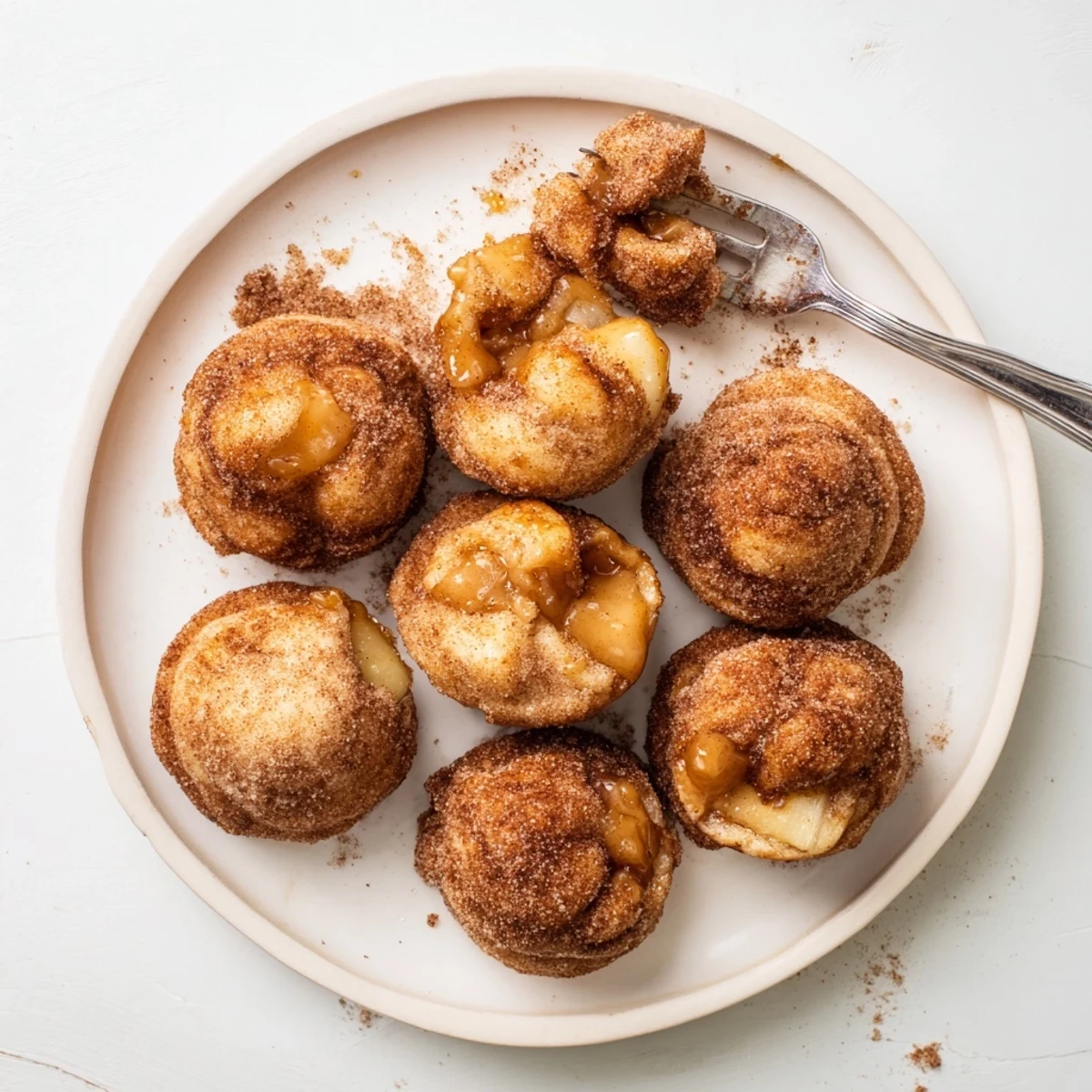 Golden brown caramel apple pie bombs with cinnamon sugar coating and oozing caramel center