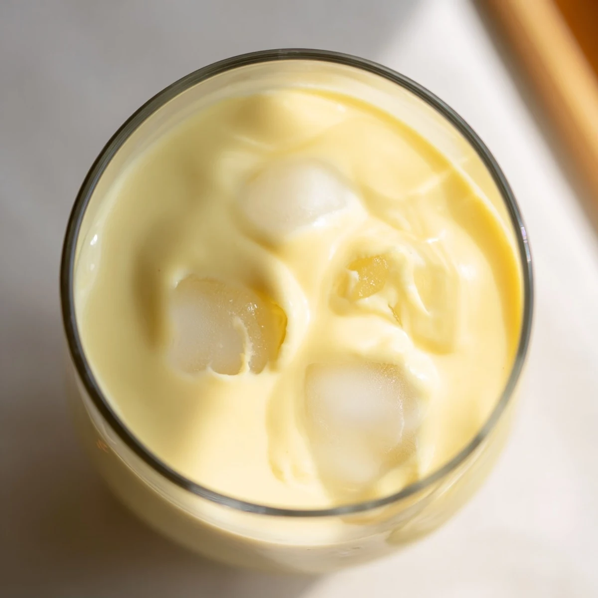 Vibrant durian smoothie topped with fresh banana slices and a drizzle of honey