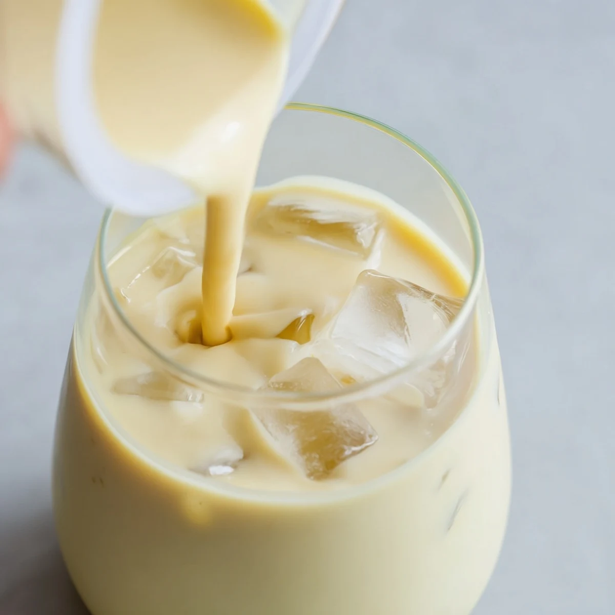 Tropical durian smoothie with ice cubes served in a tall clear glass