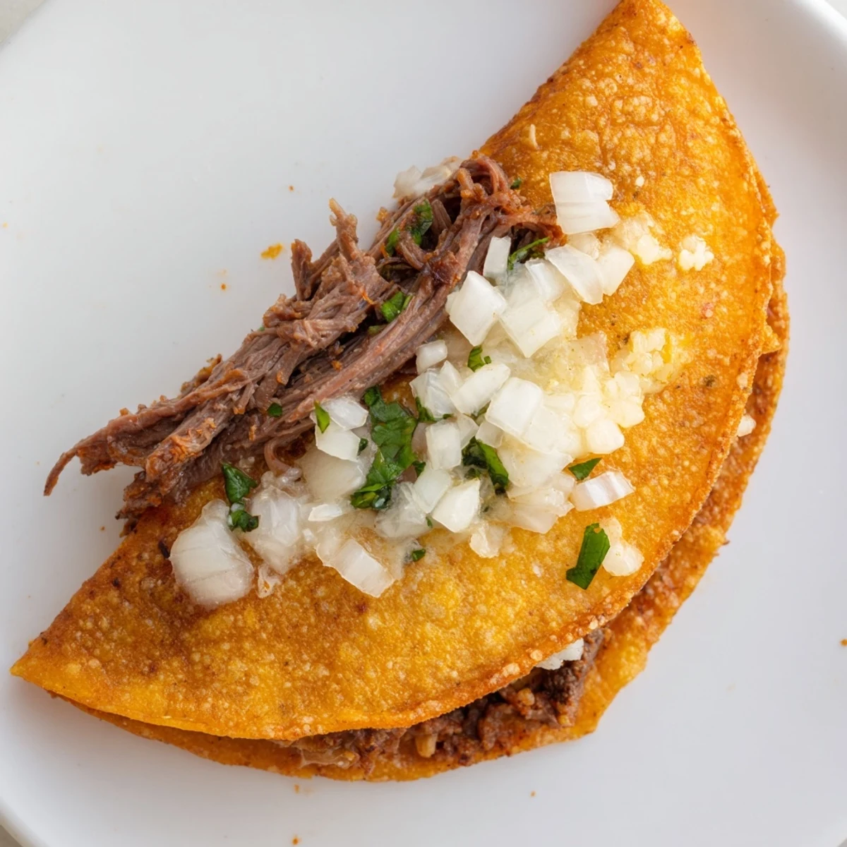 Super crispy birria tacos with melted Oaxaca cheese, fresh cilantro, and warm spiced consommé for dipping