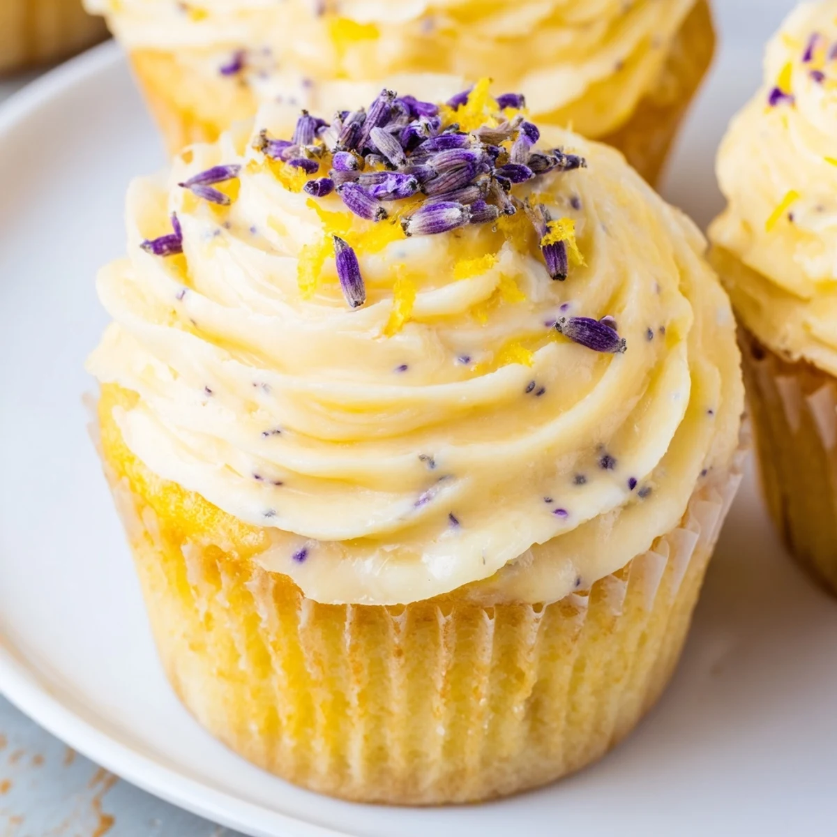 Fresh and fluffy lemon lavender cupcakes topped with creamy white frosting and sprinkled with purple lavender buds
