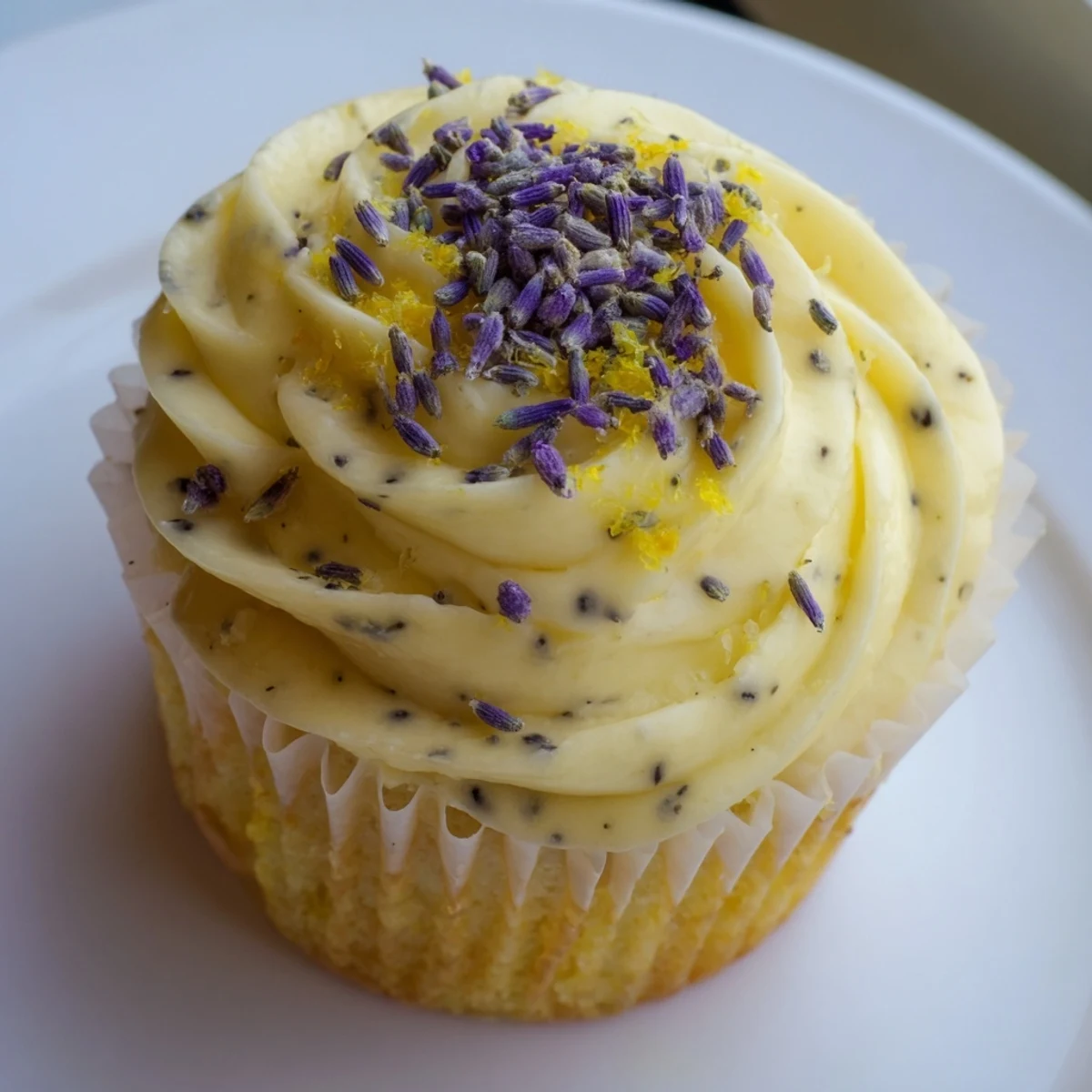 Two tender lemon lavender cupcakes with swirled buttercream frosting on a rustic wooden serving board