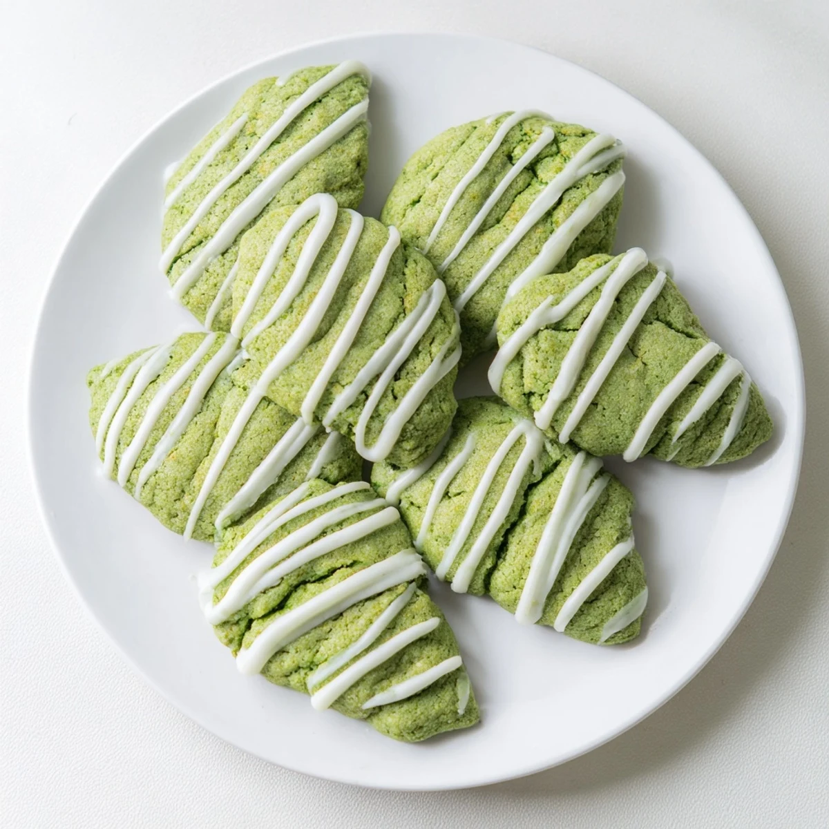 Batch of tender green velvet treats finished with melted white chocolate glaze decoration
