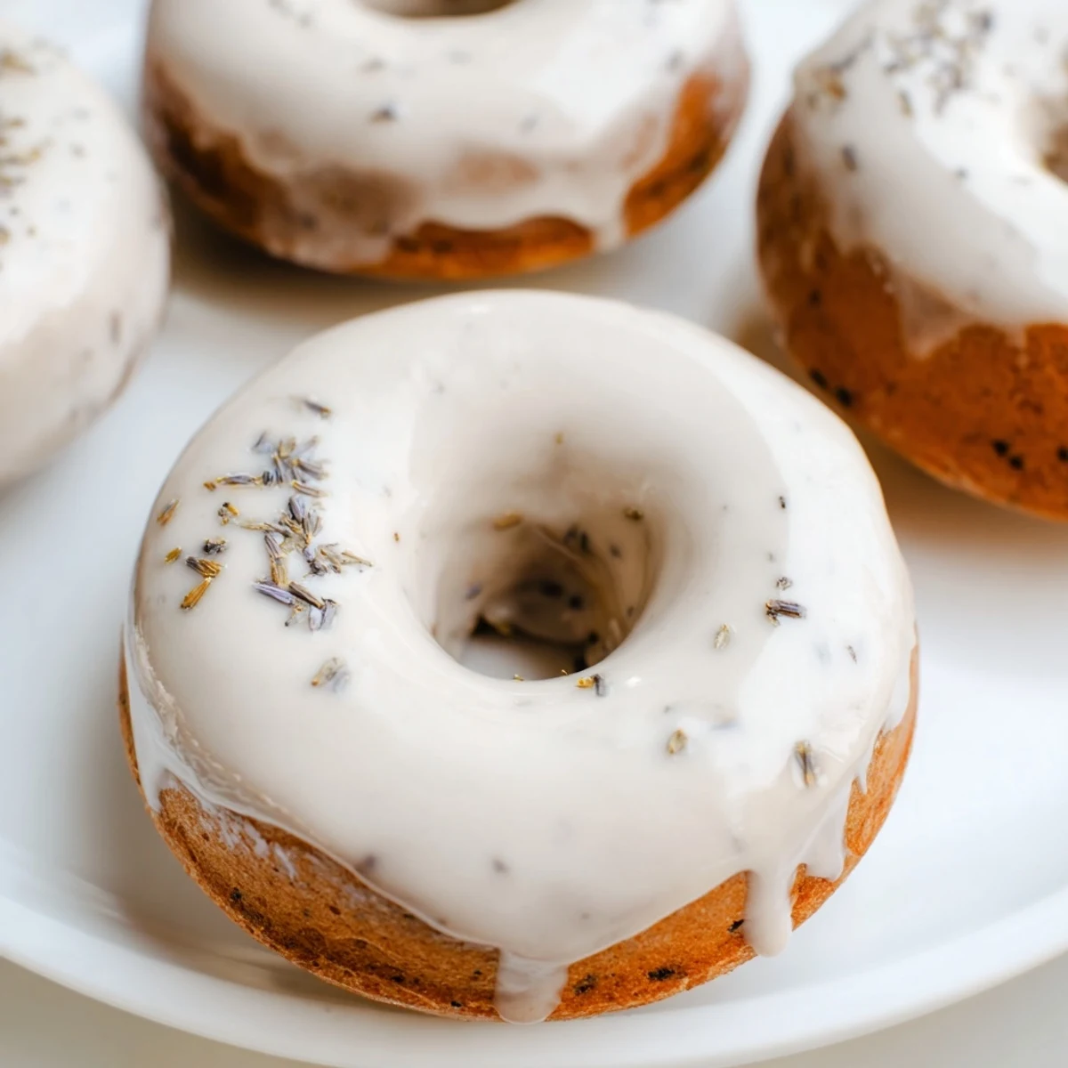 Bite-sized Earl Grey mochi donuts stacked on a white plate showcasing their crackled glaze and soft bouncy rice flour texture