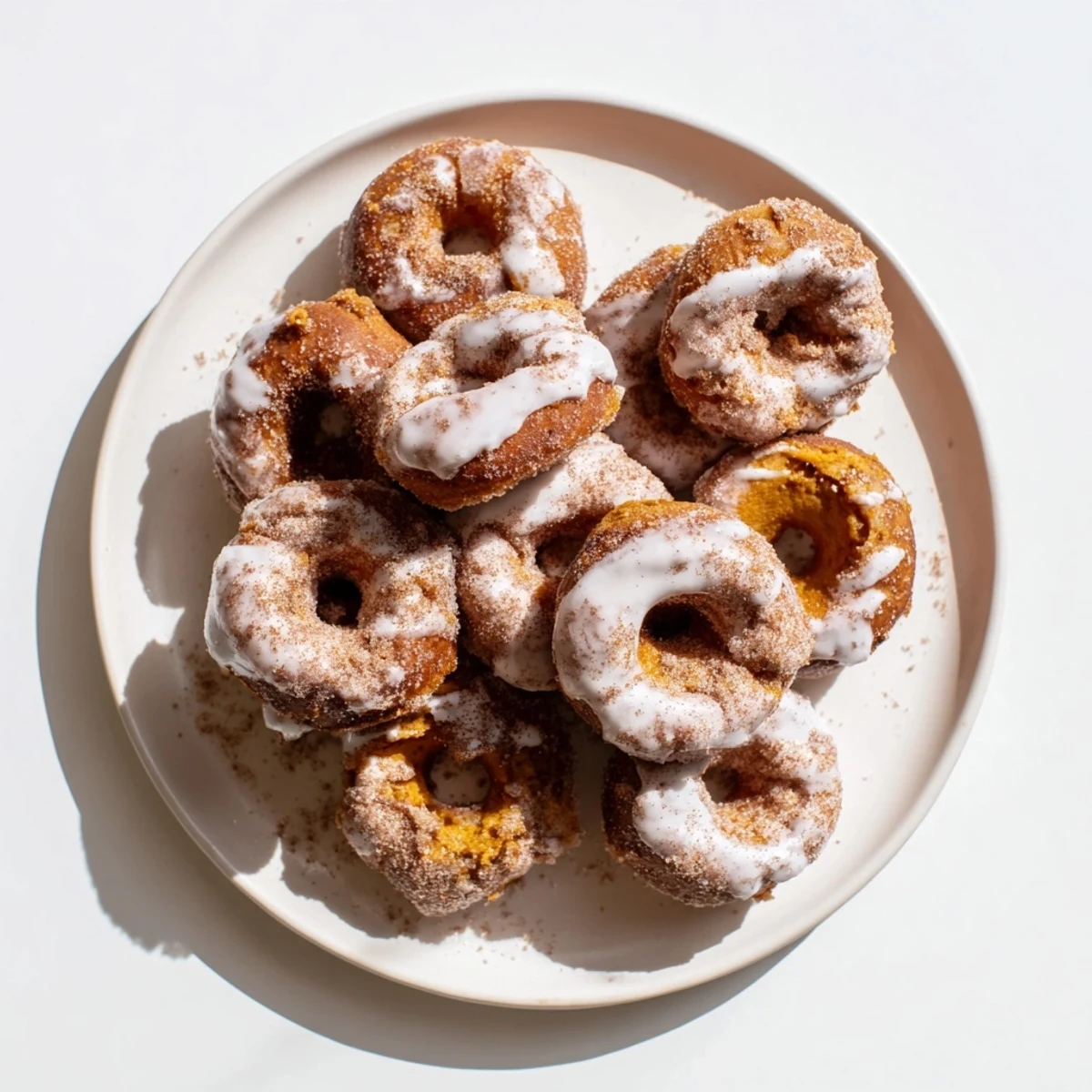 Fluffy glazed pumpkin donuts dusted with cinnamon sugar perfect for autumn breakfast treats