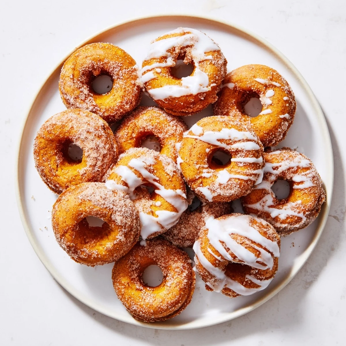 Warm fried donuts spiced with pumpkin and cinnamon on a white serving plate