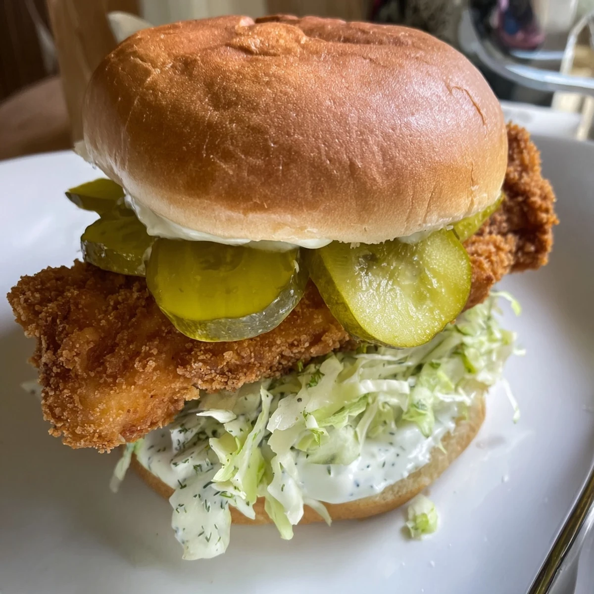 Savory fried chicken breast with fresh dill mayo and crunchy pickles in sandwich