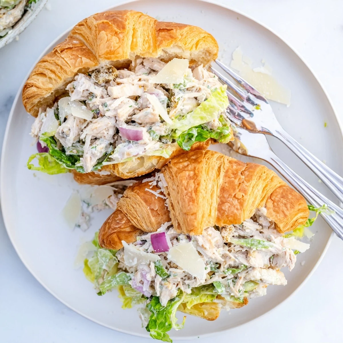 Close-up of Chicken Caesar Salad Croissant Sandwich showing layered filling and shredded chicken