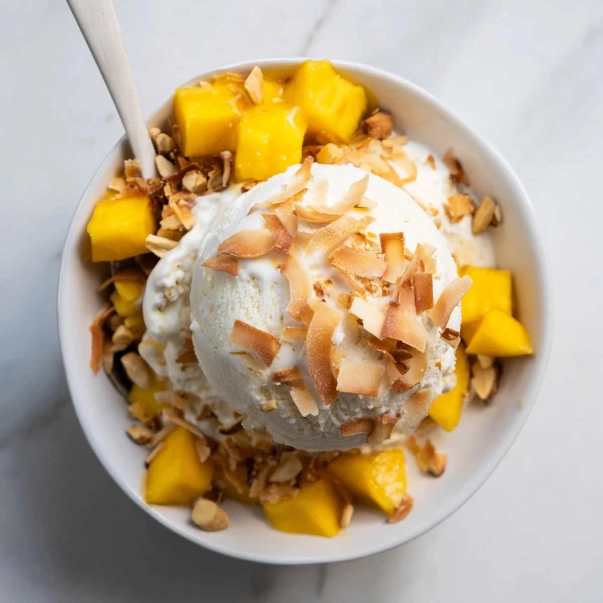 Vegan Thai coconut milk ice cream swirled with diced ripe mango and peanuts