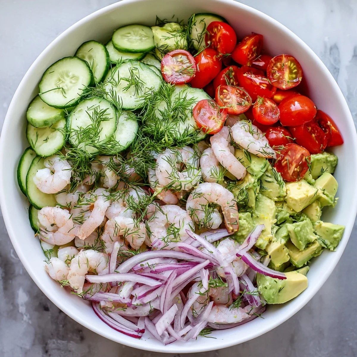 Vibrant bowl of cucumber shrimp salad tossed in olive oil dressing with fresh dill garnish