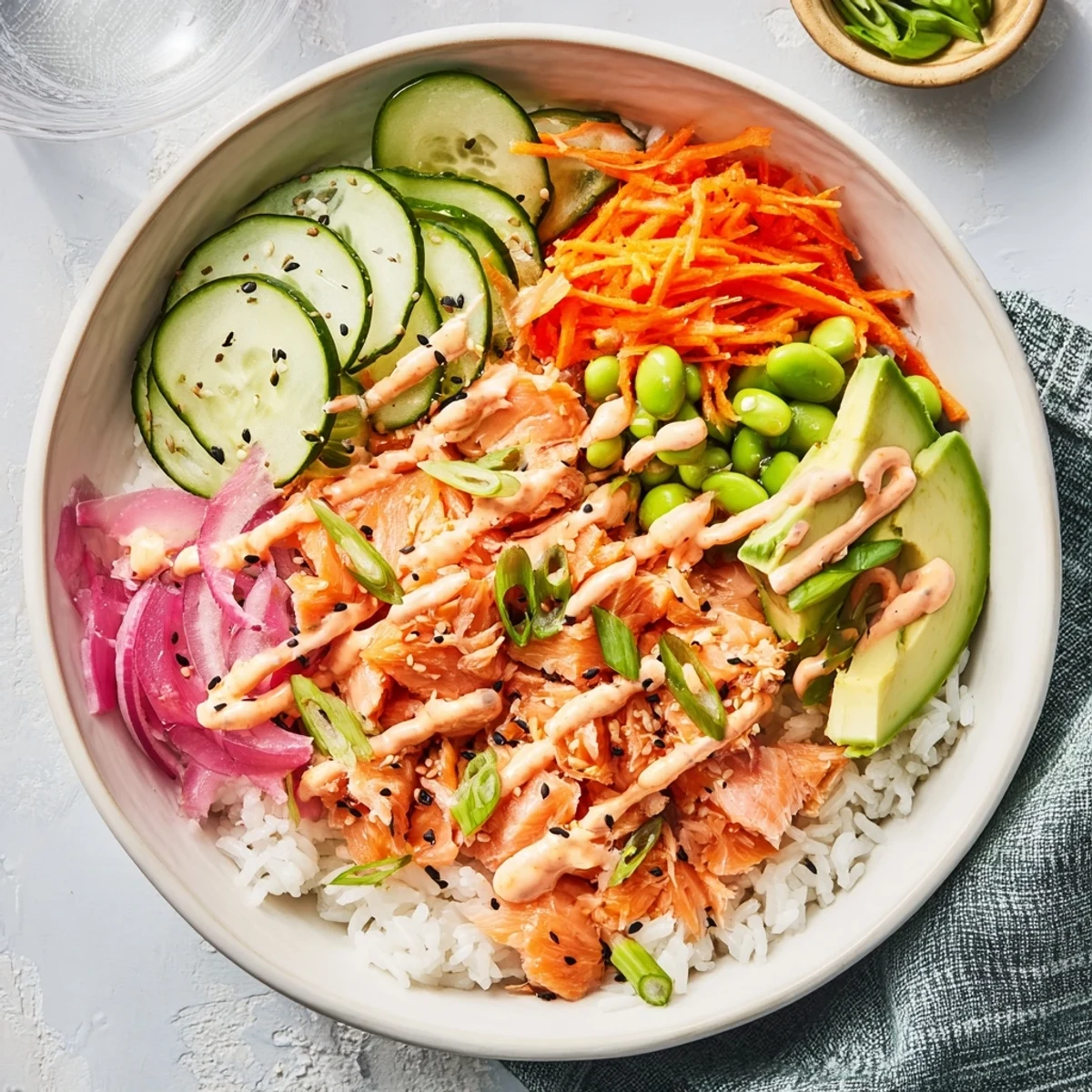 Golden baked salmon flakes rest over fluffy white rice with crisp cucumber and avocado slices