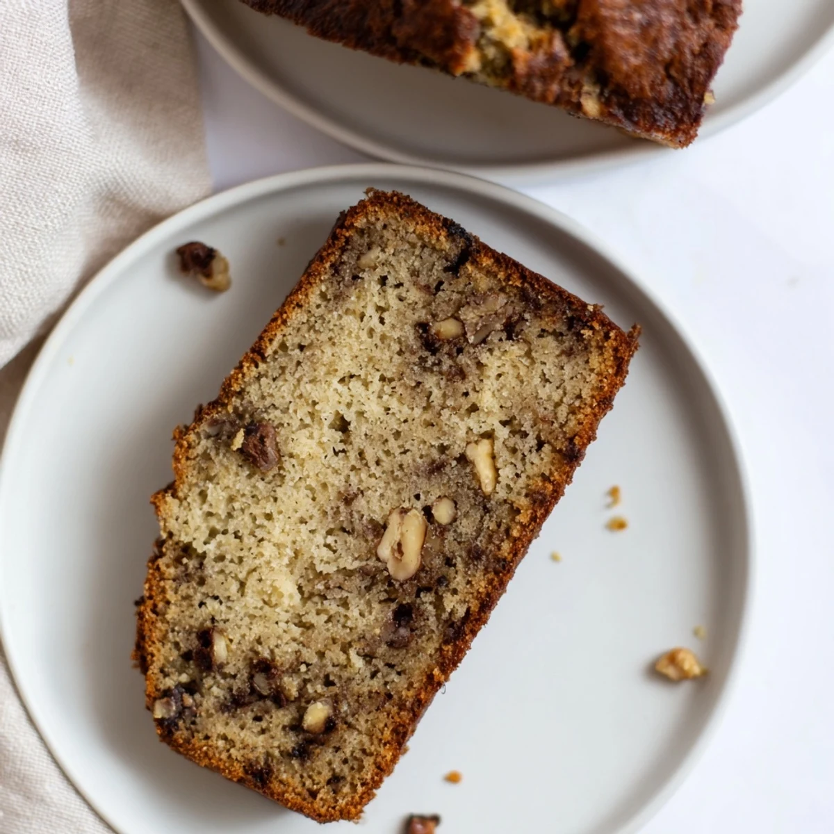 Freshly baked gluten-free banana bread in a loaf pan with a cracked, golden crust