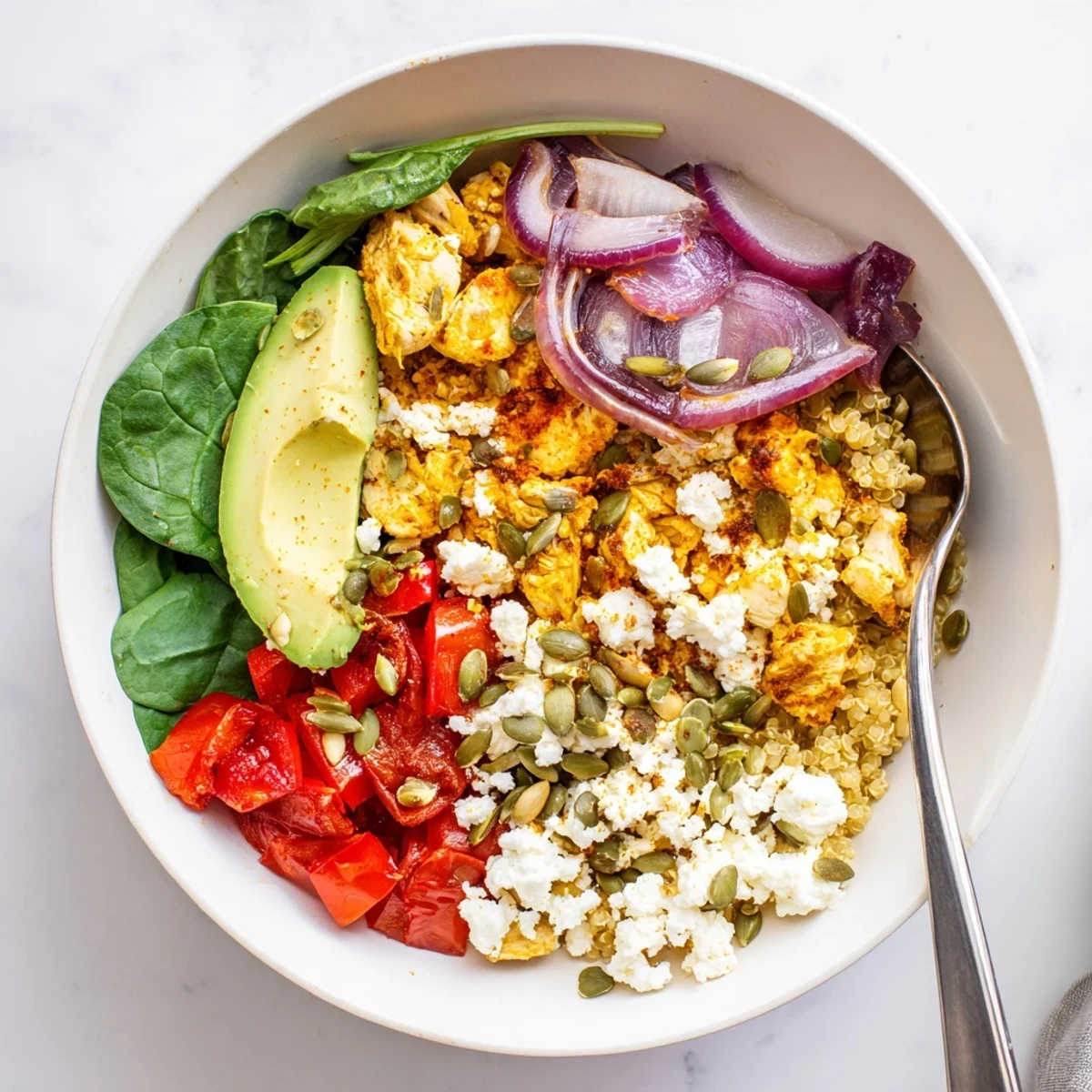 Hearty easy high protein breakfast bowl layered with quinoa, cottage cheese eggs, and vibrant diced veggies