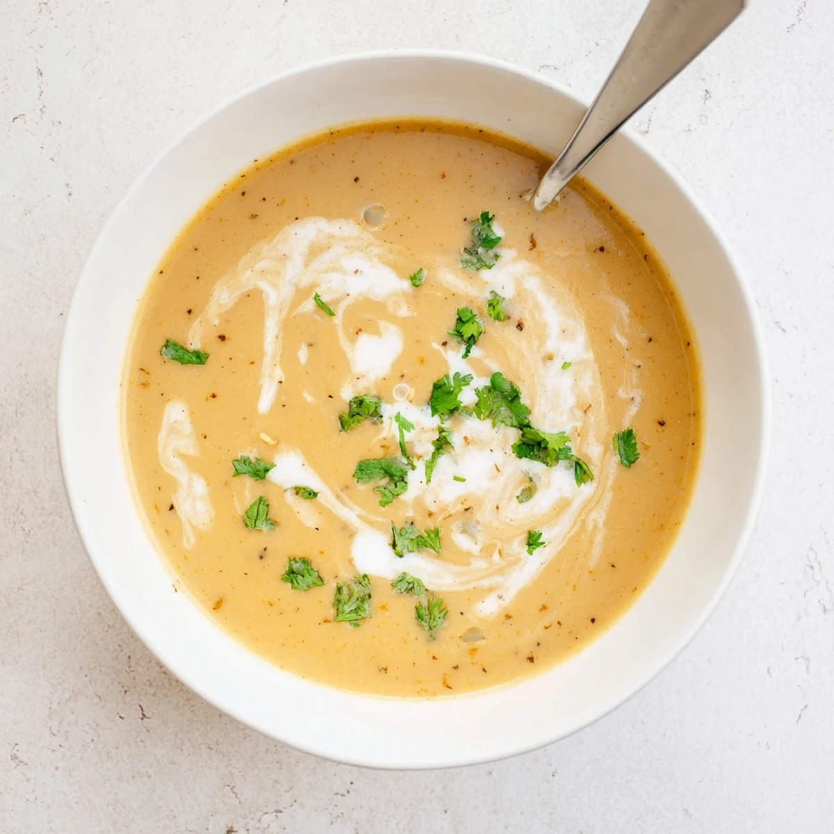 Steaming hot spicy apple soup recipe served with crusty bread and fresh coriander sprinkle