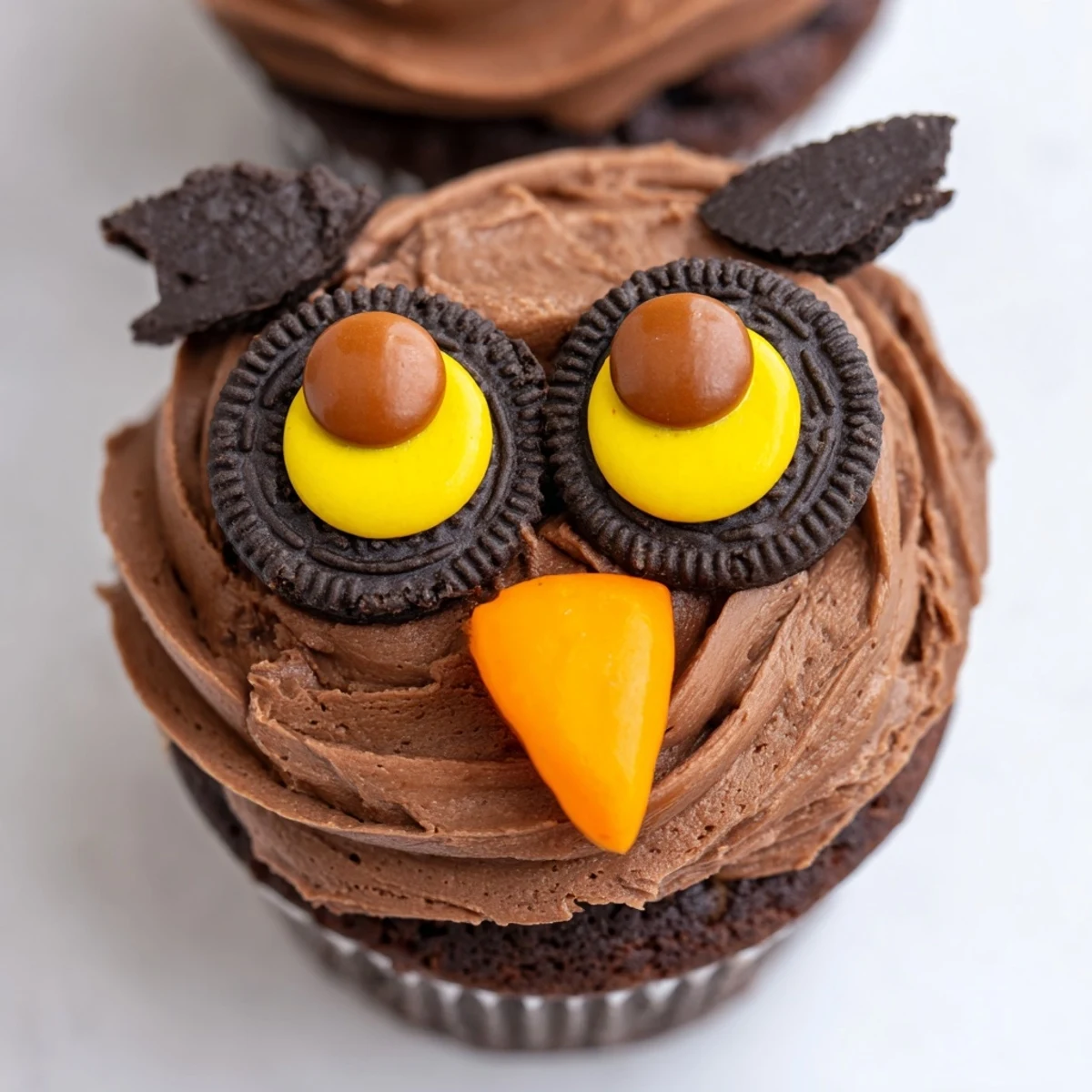 Cute Oreo Owl Cupcakes topped with creamy cookie eyes and chocolate pupils displayed together