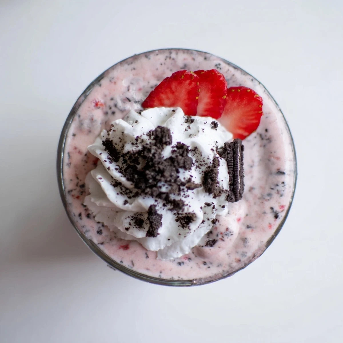 Two chilled glasses of creamy strawberry Oreo milkshake garnished with fresh strawberry slices