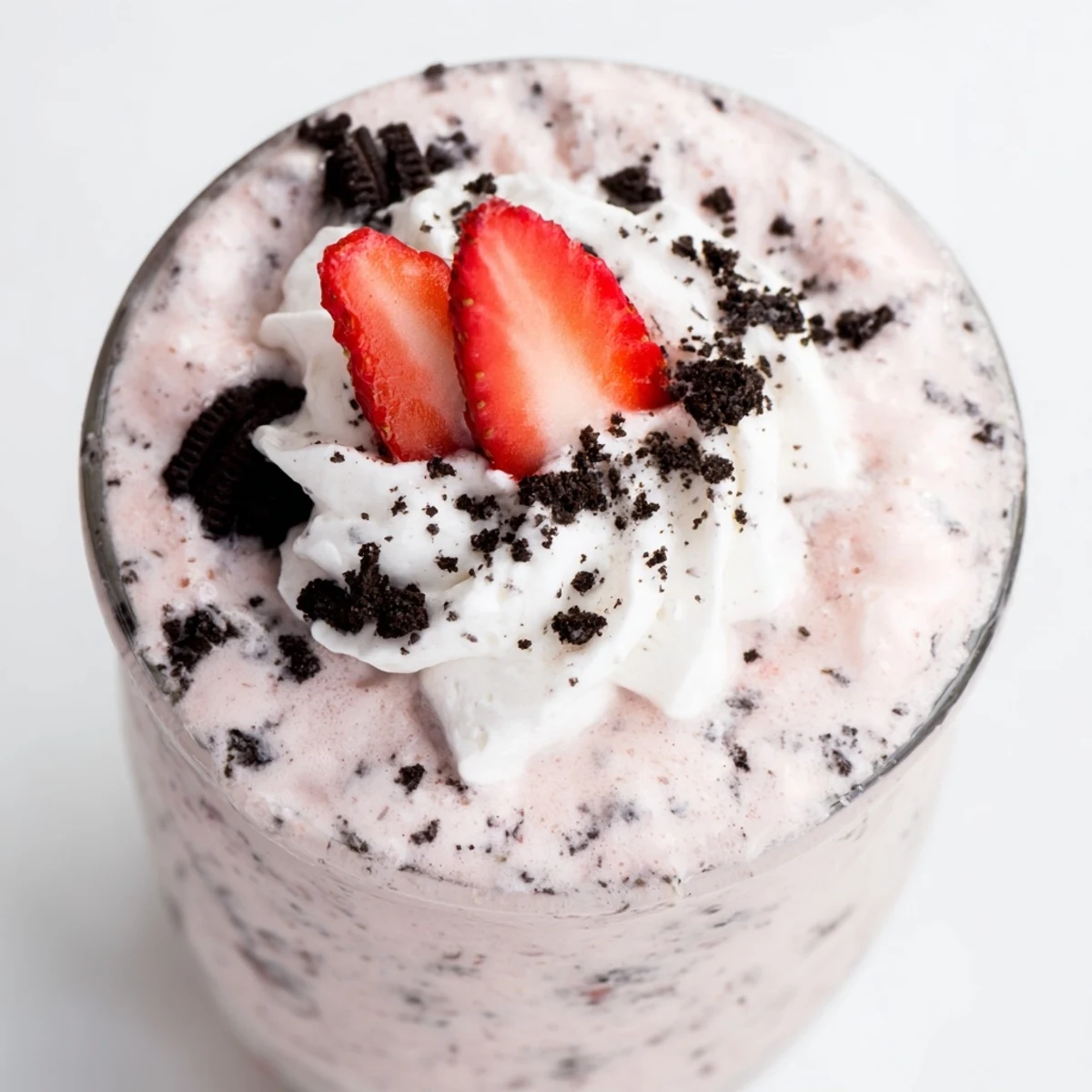 Rich strawberry Oreo milkshake swirled with chocolate cookie crumbs in a tall glass