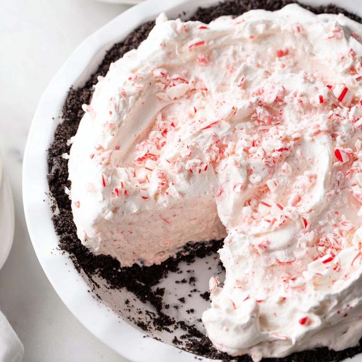 Holiday Candy Cane Pie topped with whipped cream and crunchy candy cane bits.