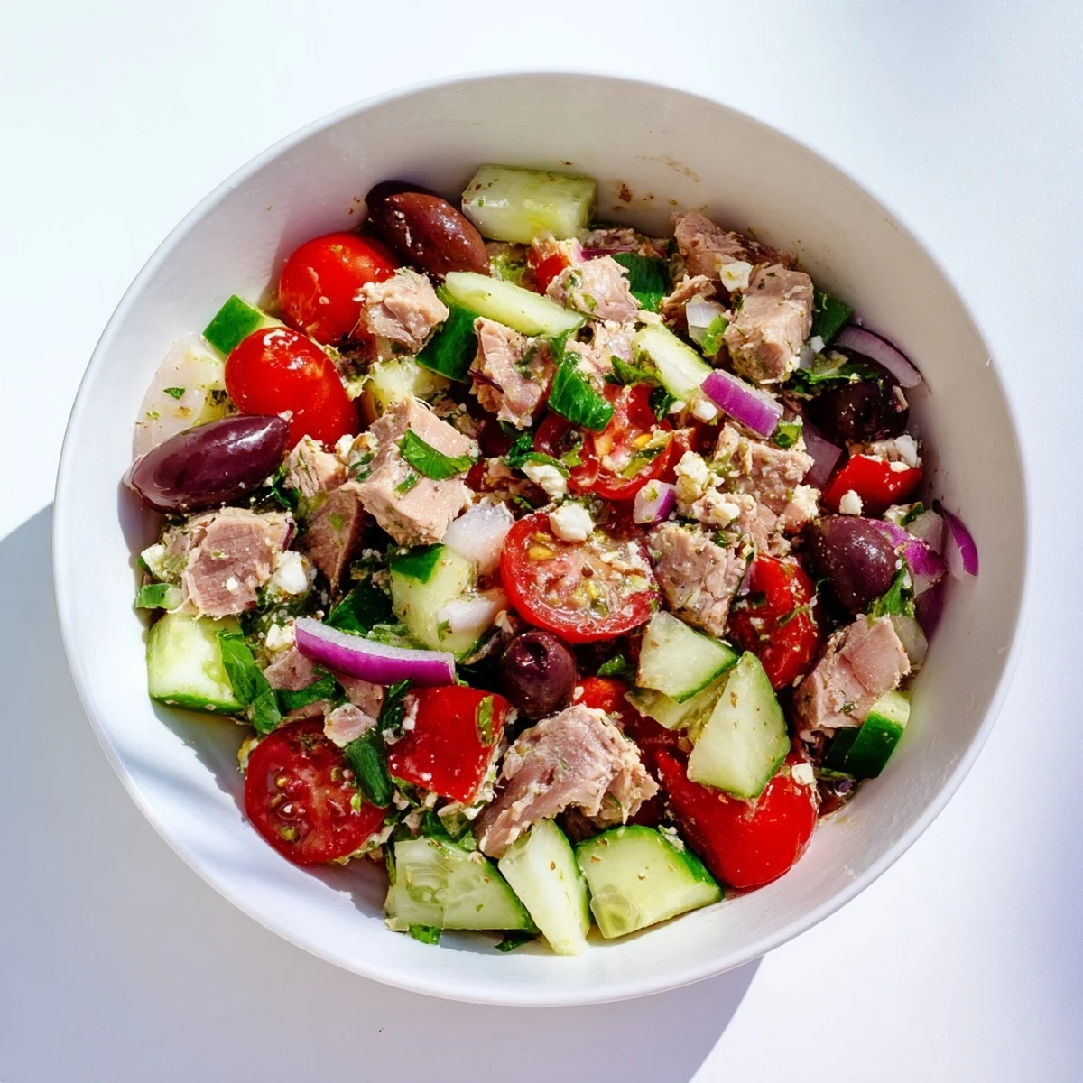 Vibrant Mediterranean tuna salad bowl topped with feta cheese, Kalamata olives, and fresh herbs.