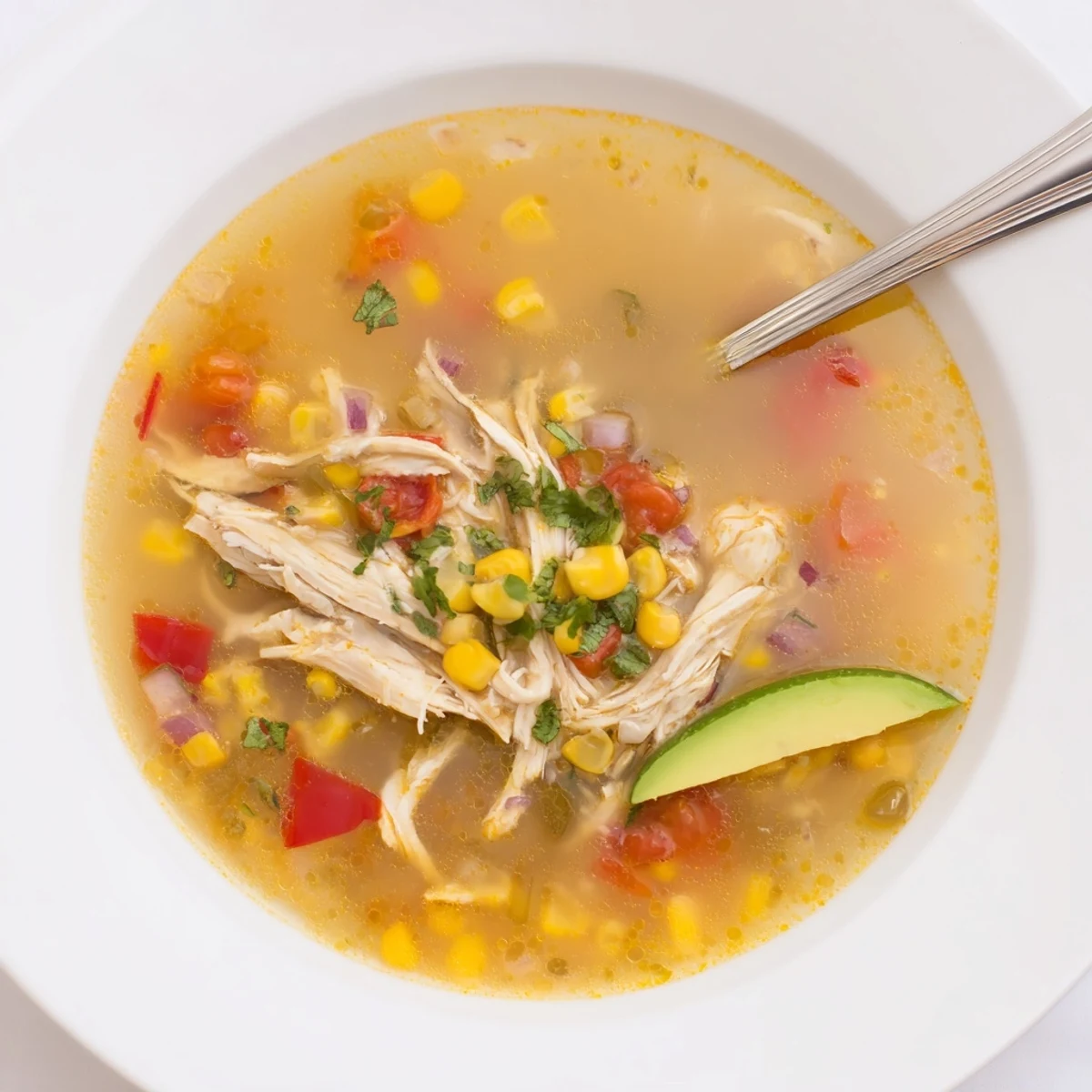 Bowl of Bold Zesty Chicken Lime Soup Recipe topped with avocado and cilantro