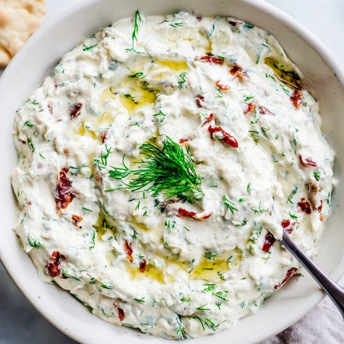 Creamy Sun Dried Tomato Tzatziki in bowl, velvety yogurt, bright tomato bites.
