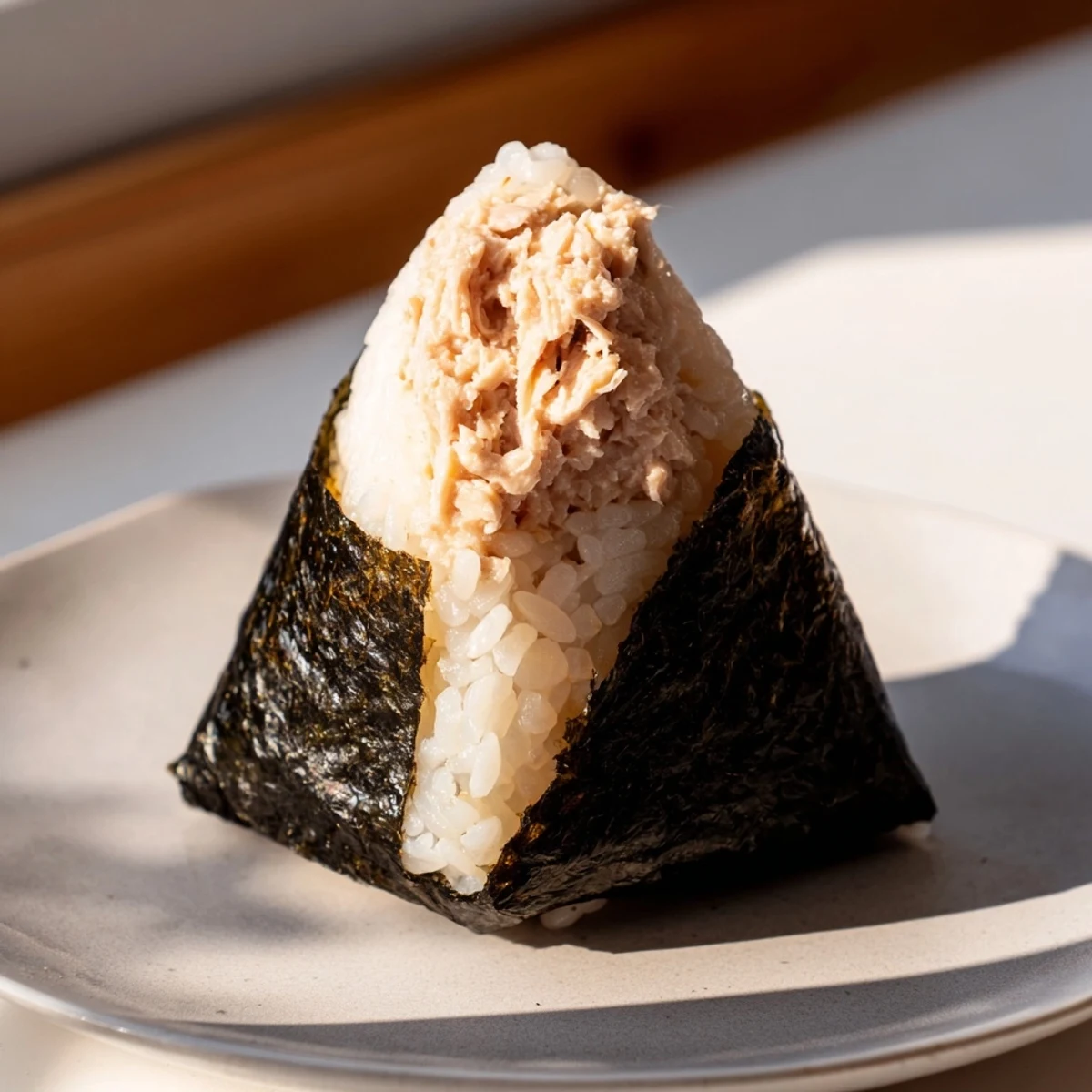 Classic tuna mayo onigiri featuring tender seasoned rice and golden flaky tuna center