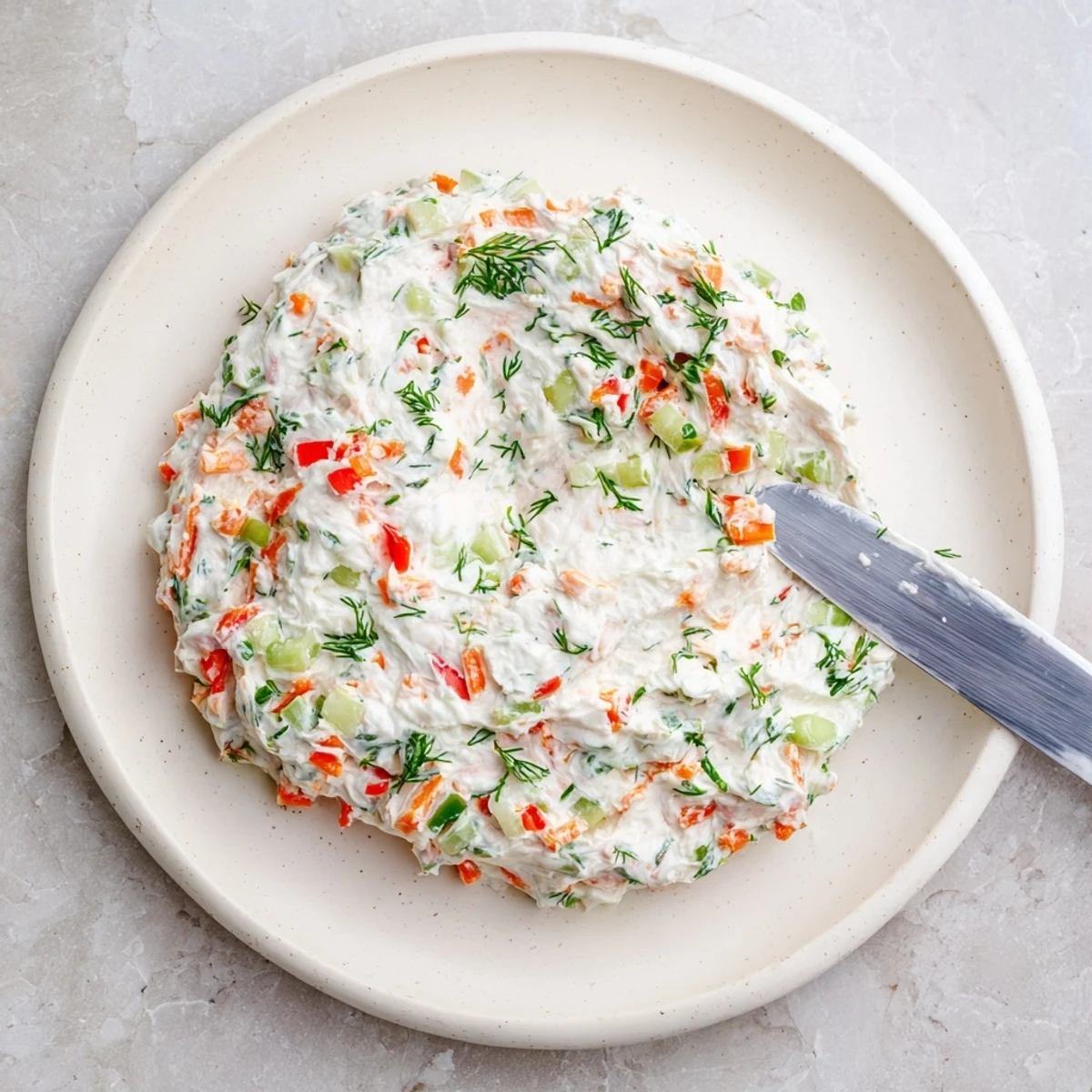 Spoonful of garden vegetable spread showing vibrant vegetables mixed into creamy base