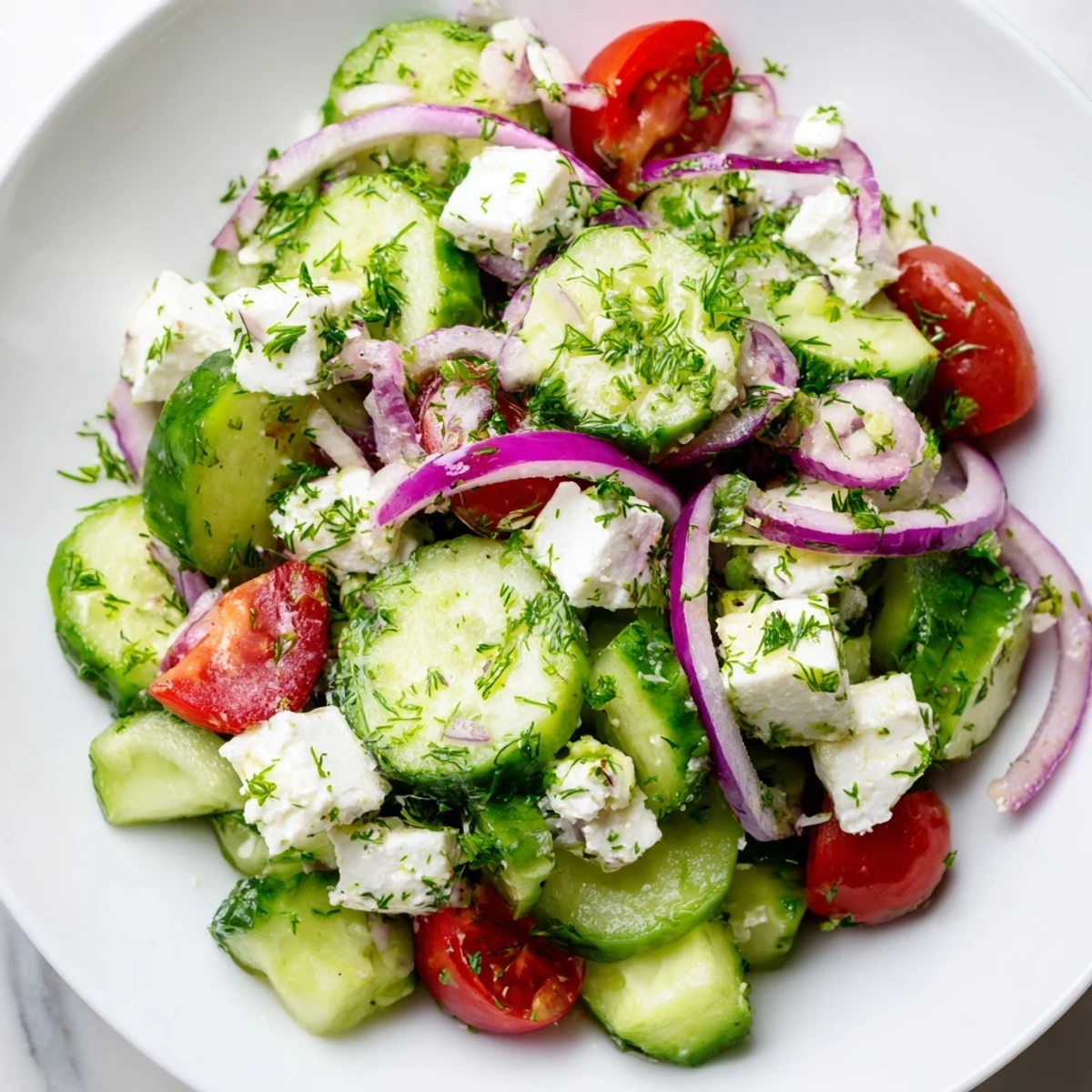 Creamy feta cheese coats crunchy cucumber slices and colorful herbs in this refreshing Feta Cucumber Herb Salad.