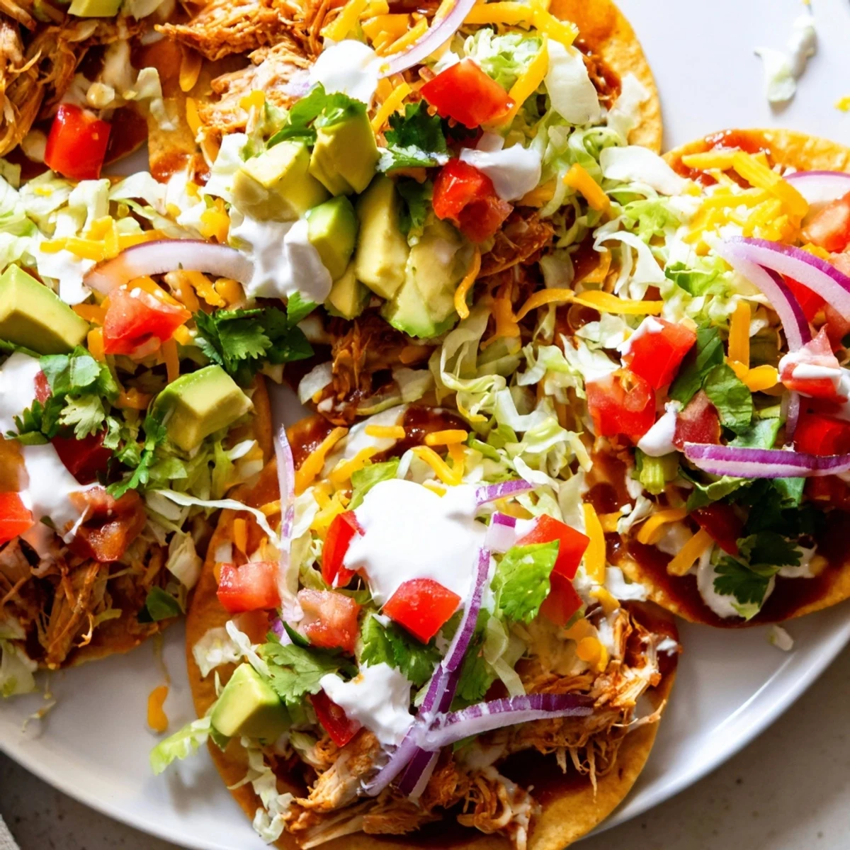 Golden tostada shells loaded with tender sweet smoky BBQ chicken, crisp lettuce, and tangy sour cream.