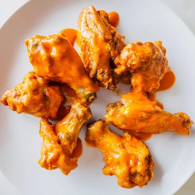 A platter of spicy Buffalo chicken wings, baked to crisp perfection and tossed in tangy red sauce.
