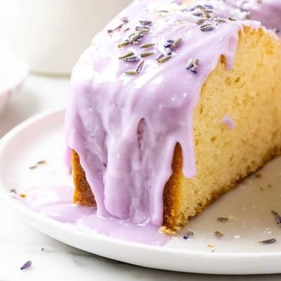 Purple-hued lavender glaze pooling on freshly baked sugar cookies with floral sweetness